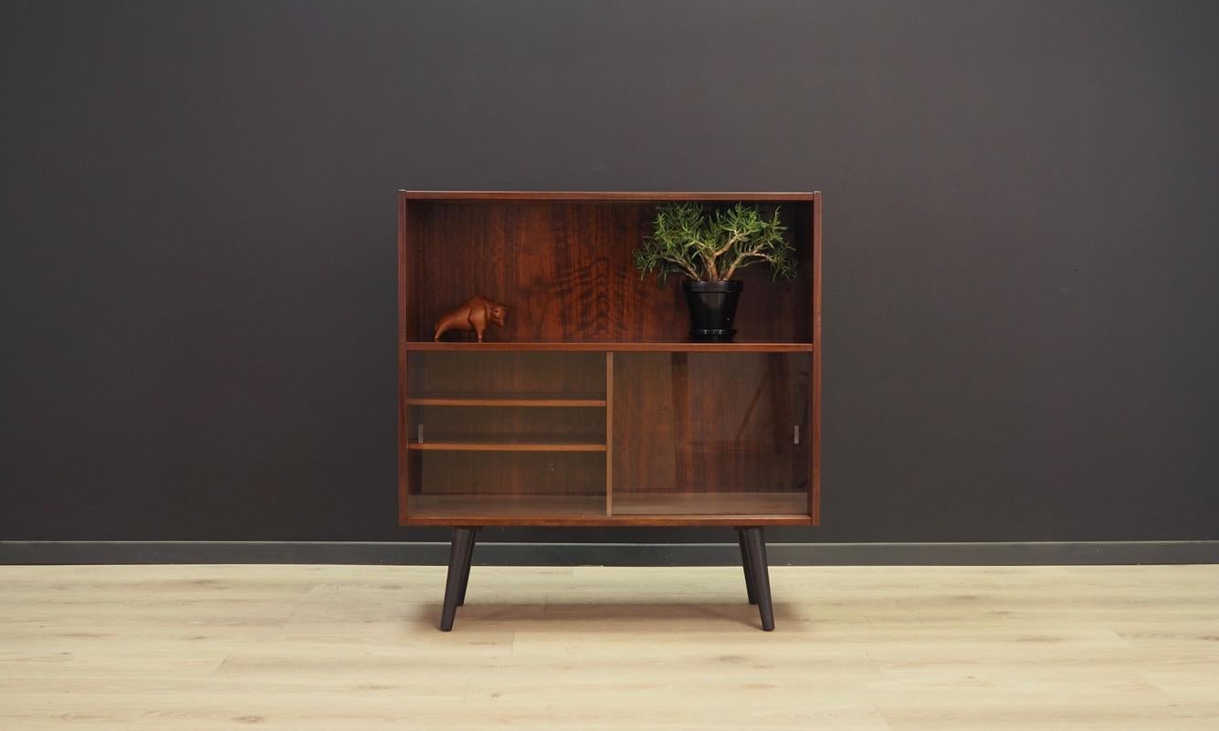 Brilliant bookcase - library from the 1960s-1970s, Scandinavian design. Furniture finished with rosewood veneer. Two shelves behind glass doors. Maintained in good condition (minor bruises and scratches) - directly to use.

Dimensions: height 95