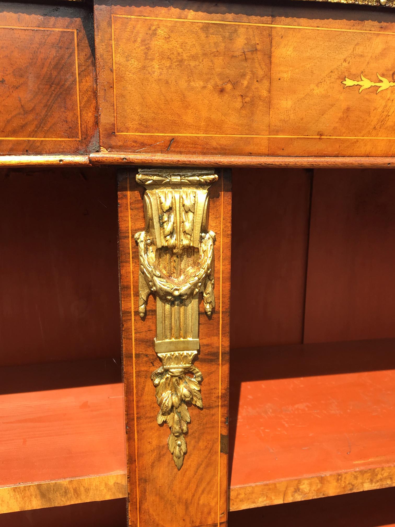 Good quality walnut and marquetry bookcase. English circa 1880.
This delightful antique bookcase is craftsman made with figured Walnut veneers
and areas of satinwood marquetry panels and ormolu mounts
It has 6 adjustable shelves with a shelf