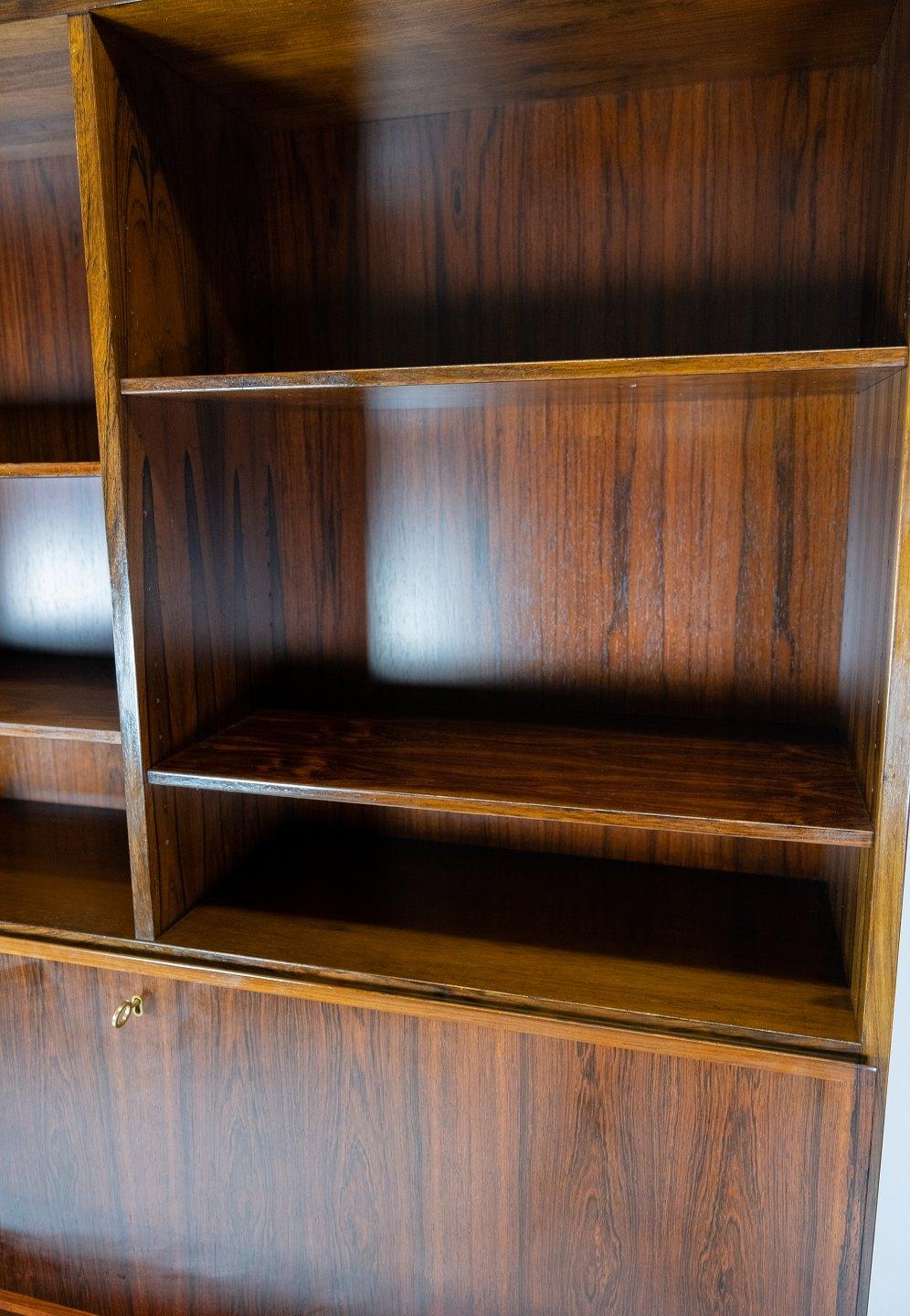 Get an authentic piece of Danish furniture history with this beautiful bookcase with secretary in rosewood, model no. 9, designed by Omann Junior in the 1960s. This bookcase is an excellent example of the timeless elegance and fine craftsmanship