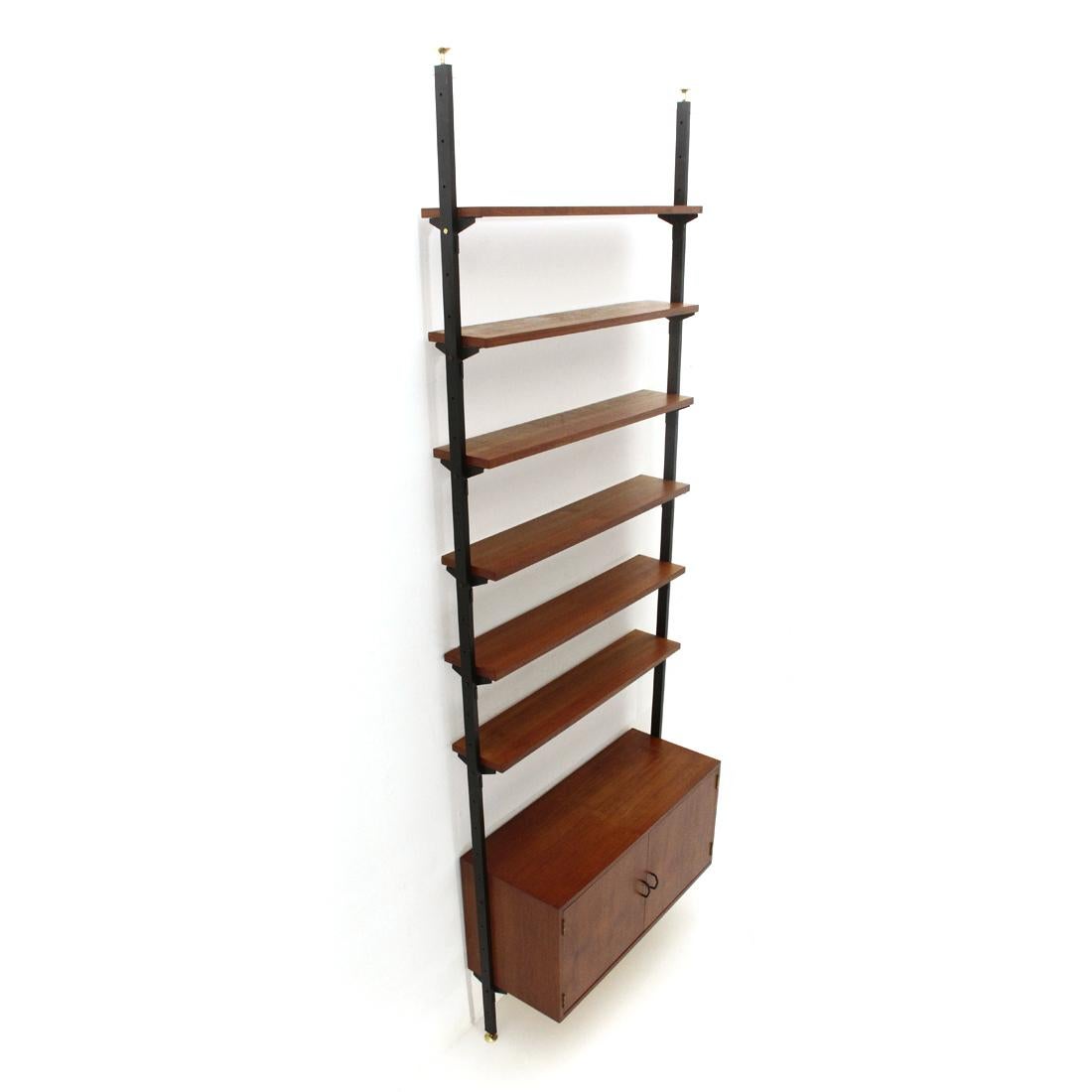 Italian-made bookcase produced in the 1960s.
Uprights in black painted metal with height-adjustable brass feet.
Container in teak veneered wood, handles in black painted metal.
Shelves in teak veneered wood.
Good general condition, some signs