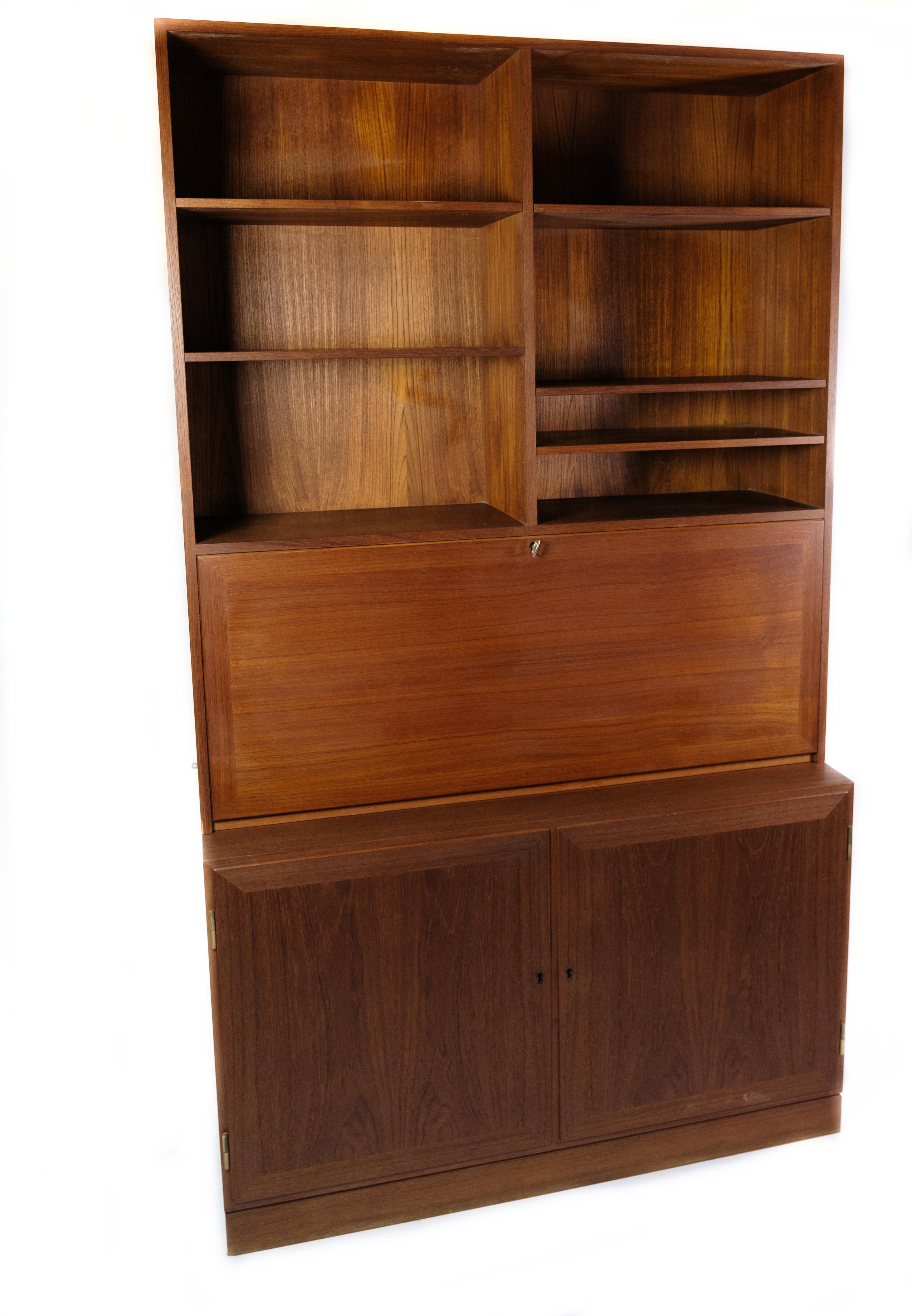 Made of teak and dating from the 1960s, this impressive bookcase with secretary/desk is a masterpiece of functionality and aesthetics. With its beautiful teak wood and characteristic design, this bookcase exudes a timeless elegance and simplicity