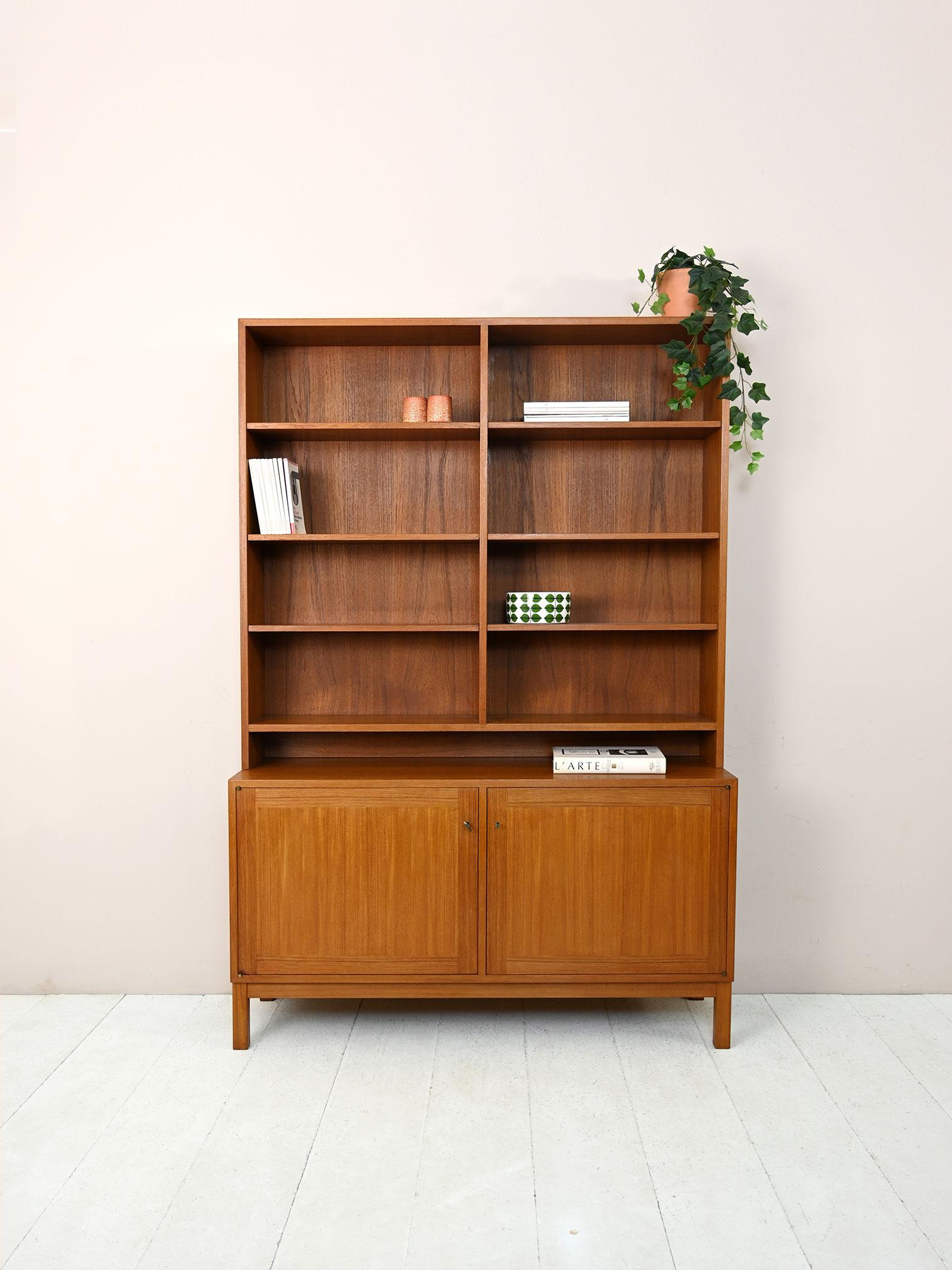 Vintage teak cabinet with shelving.

This Scandinavian sideboard fulfills the function of both a storage cabinet and a bookcase.
The lower part is a cabinet with hinged doors, while the upper part is a structure with adjustable height