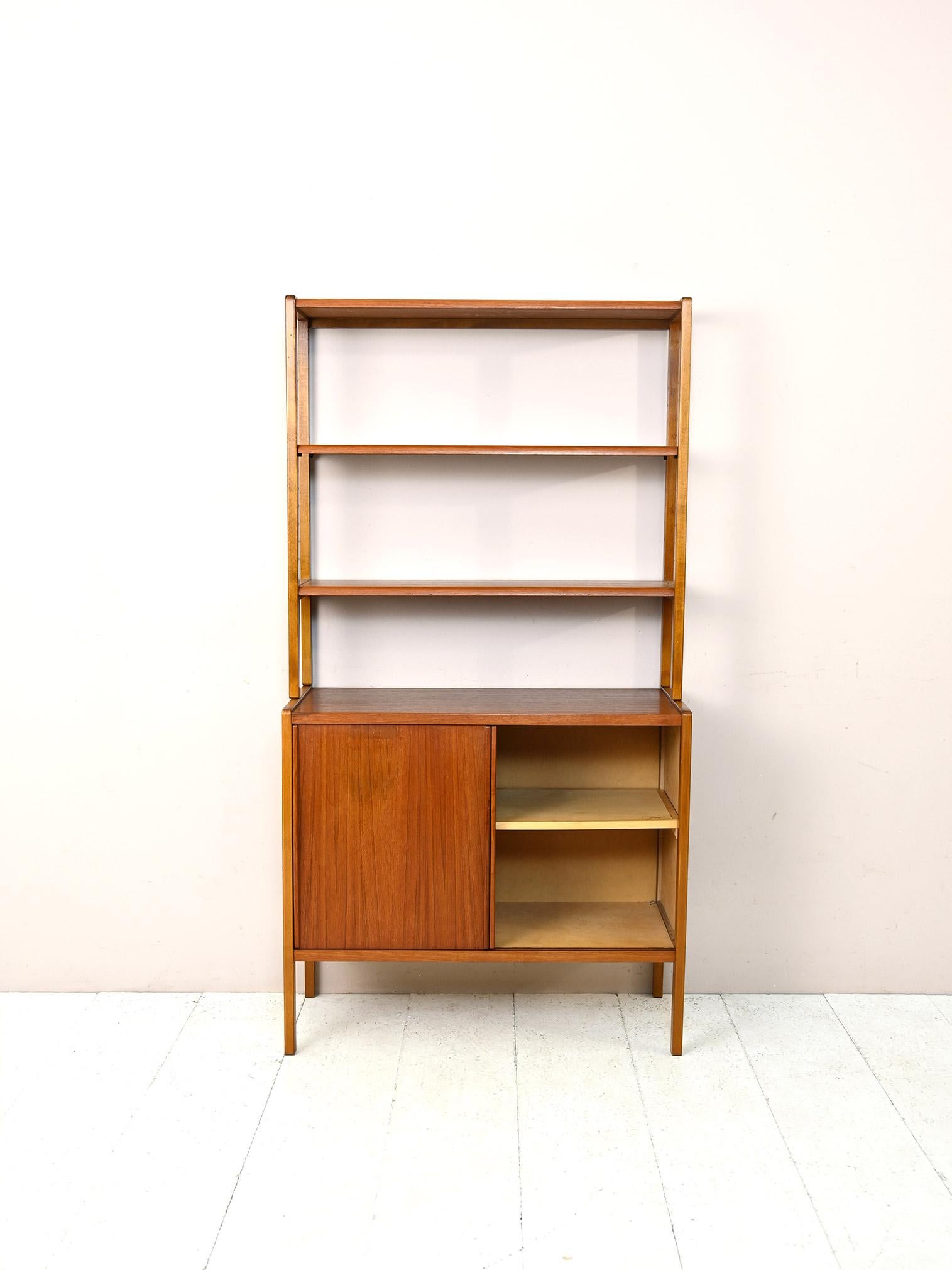 Scandinavian 1960s shelving cabinet.

This bookcase consists of two modules: the lower part is a storage unit with sliding doors, the upper part is an adjustable-height shelving system.
Simple appearance and a focus on functionality are the