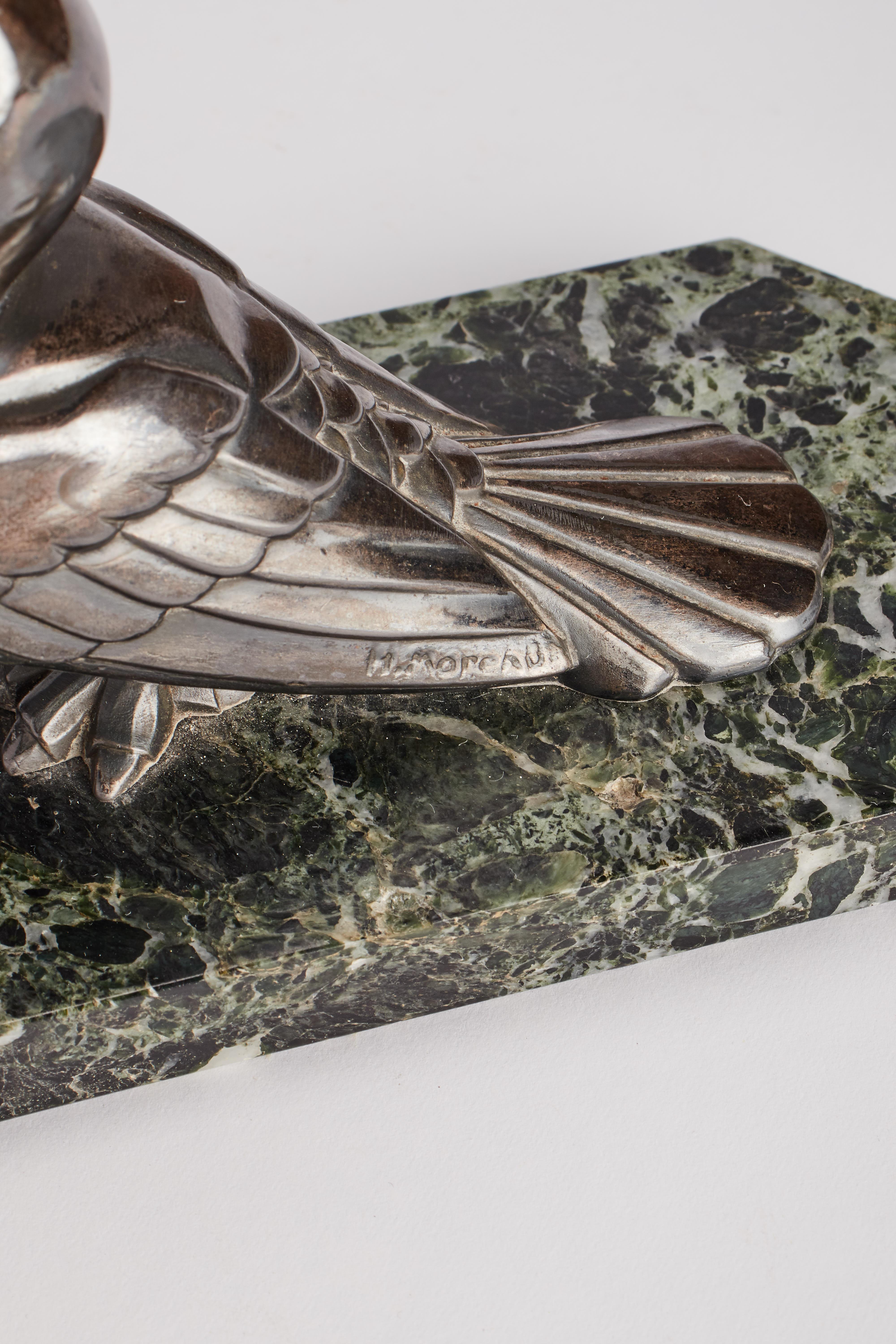 Pair of bookends. Green-veined marble. Over the L marble base, two identical white metal sculptures of birds Toucans, with a ball of amber in its beak. Art Deco’. Signed H. Moreau, France, circa 1925.