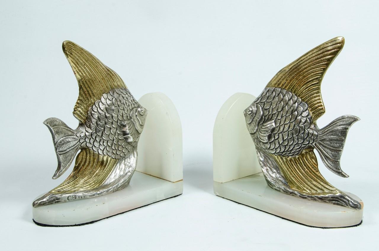 Vergoldete Buchstützen mit zwei tropischen Fischen auf Marmorsockeln, um 1930. Sie sind in einer interessanten Kombination aus silbernen Körpern und goldenen Schwänzen und Flossen patiniert. Die Körper der Fische sind natürlich mit einem