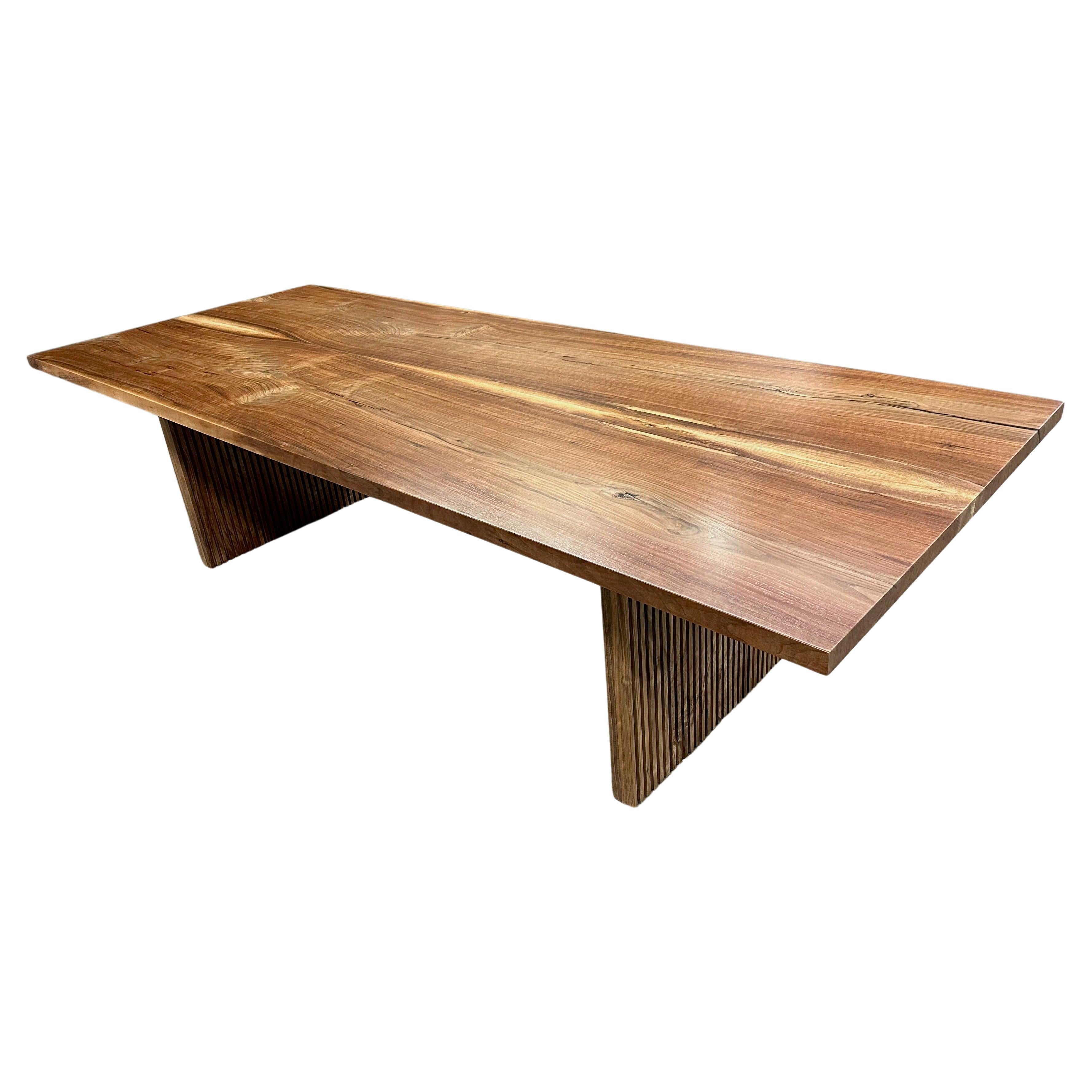 Bookmatched walnut top dining table with fluted walnut legs
