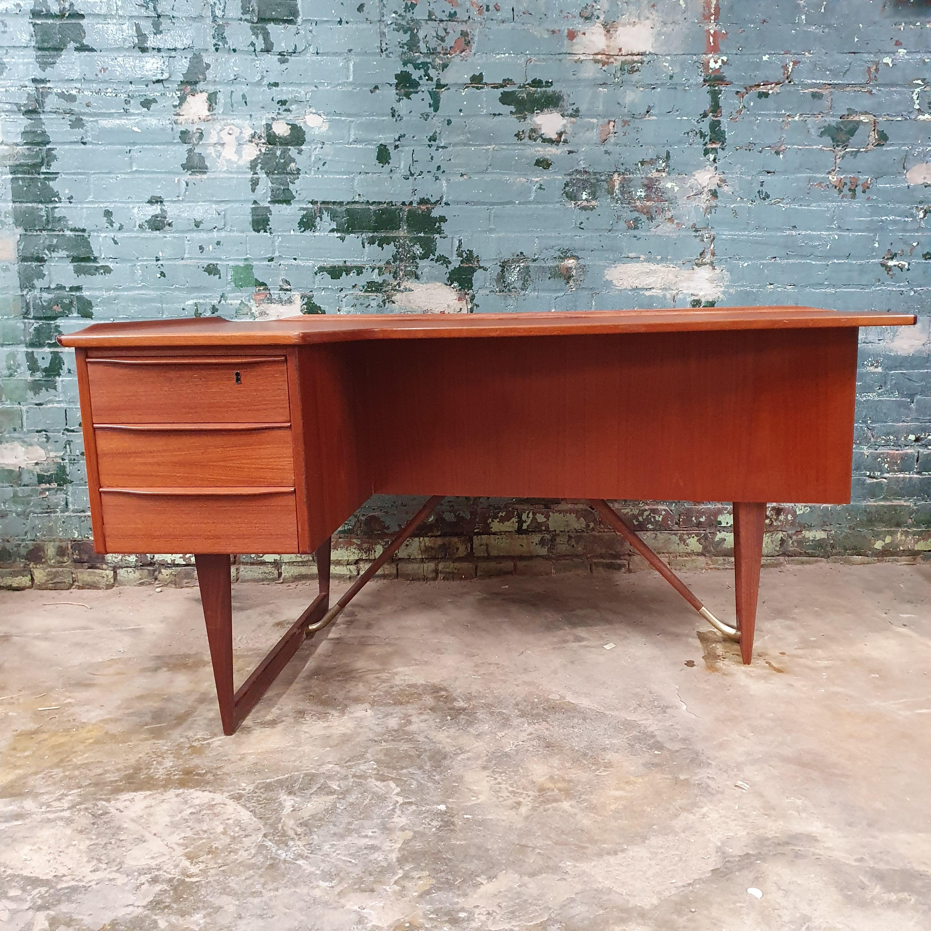 beautifully refinished teak boomerang Desk by Peter Lovig Nielsen circa 1965. raised lip edges with three drawers with a bookcase bar cabinet on the reverse side. amazing leg design with brass details. has one key for the bar cabinet and drawer.