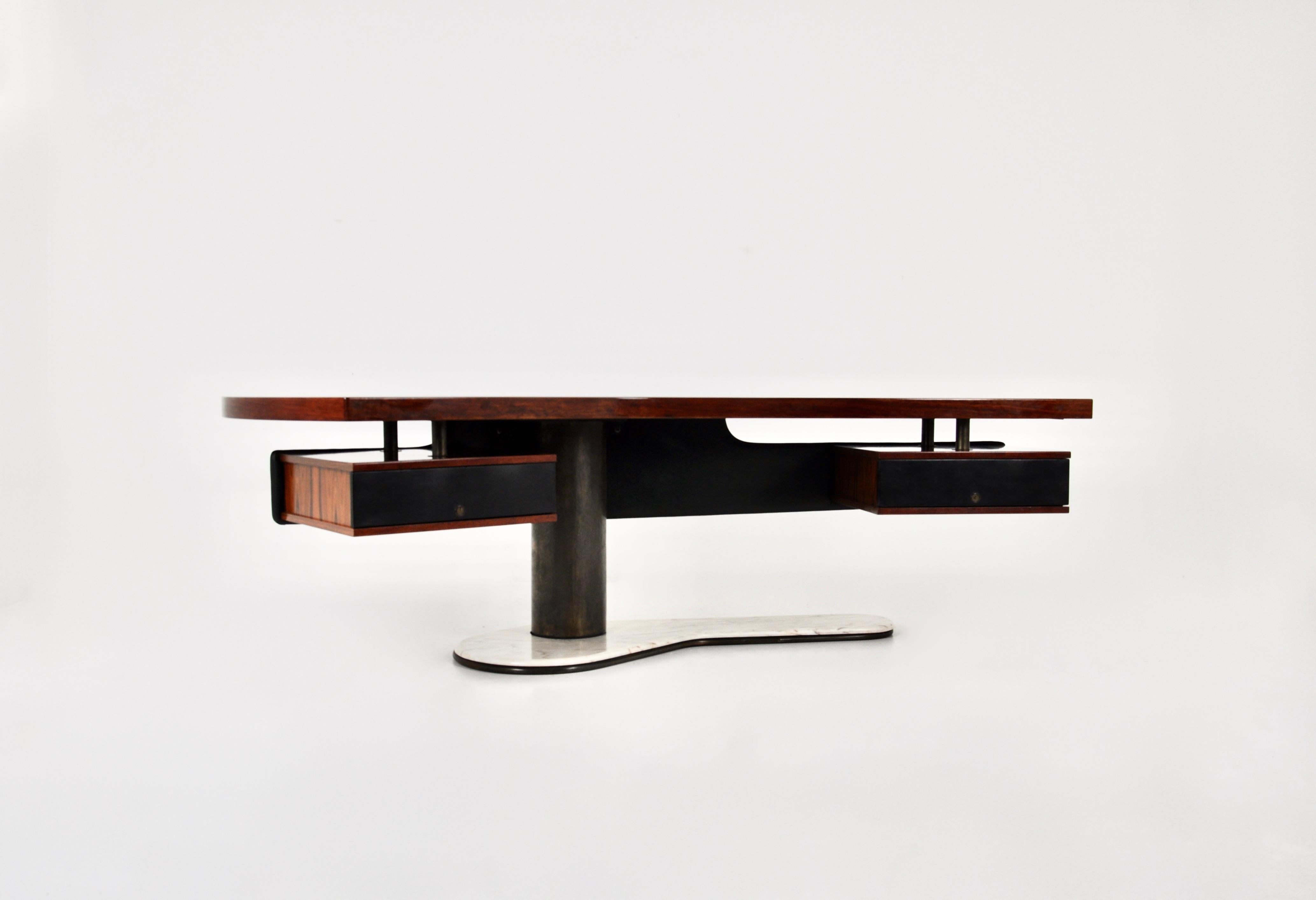 Incredible boomerang desk with floating leather back panel and wooden and leather drawers. The leg of the desk is made of marble. Wear due to time and age of the desk
