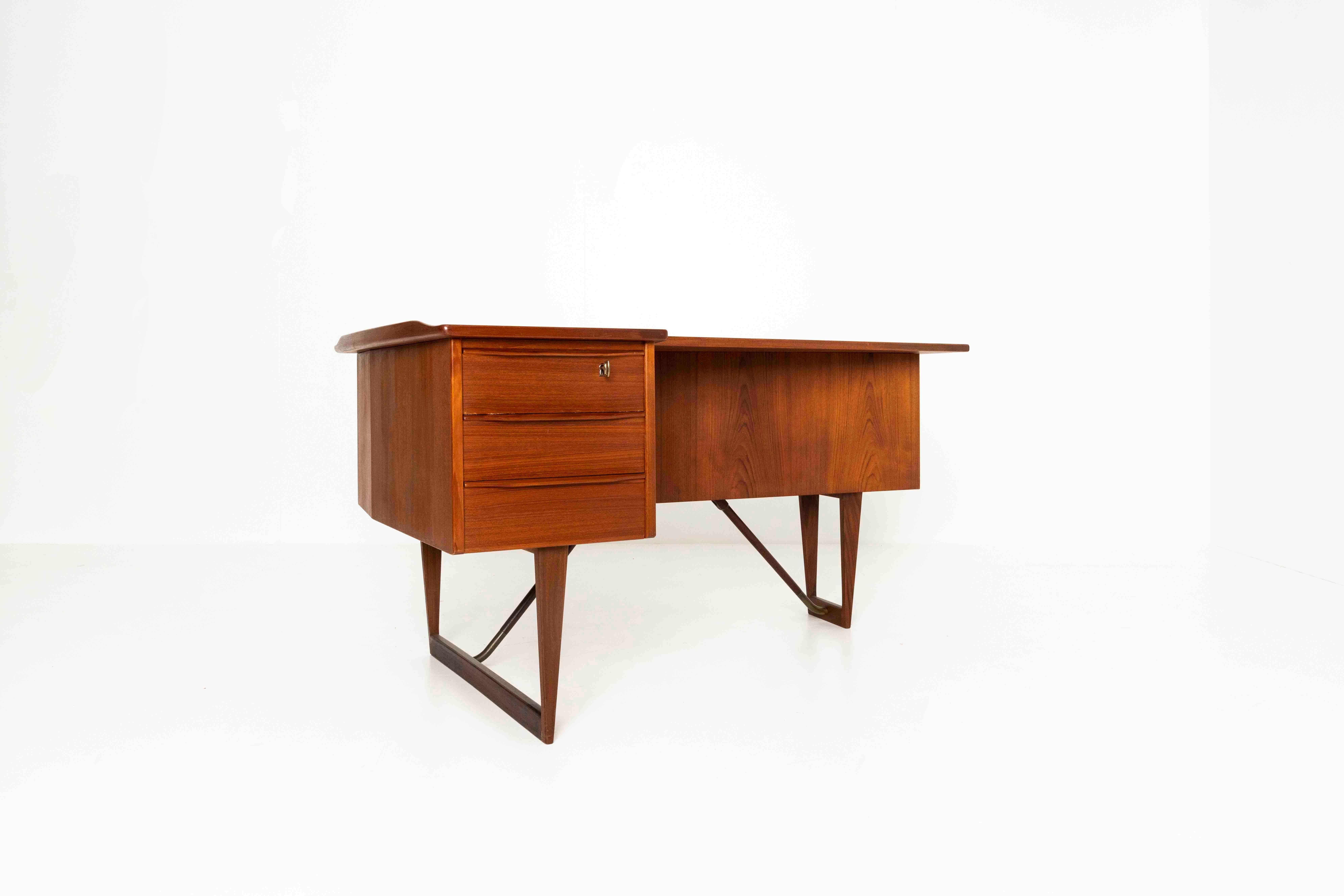 Nice boomerang desk in teak by Peter Løvig Nielsen from Denmark, 1960s. This desk can be positioned in the middle of the room, as it is very attractive from both sides. The back has a cabinet and shelves for books, whereas the front is very