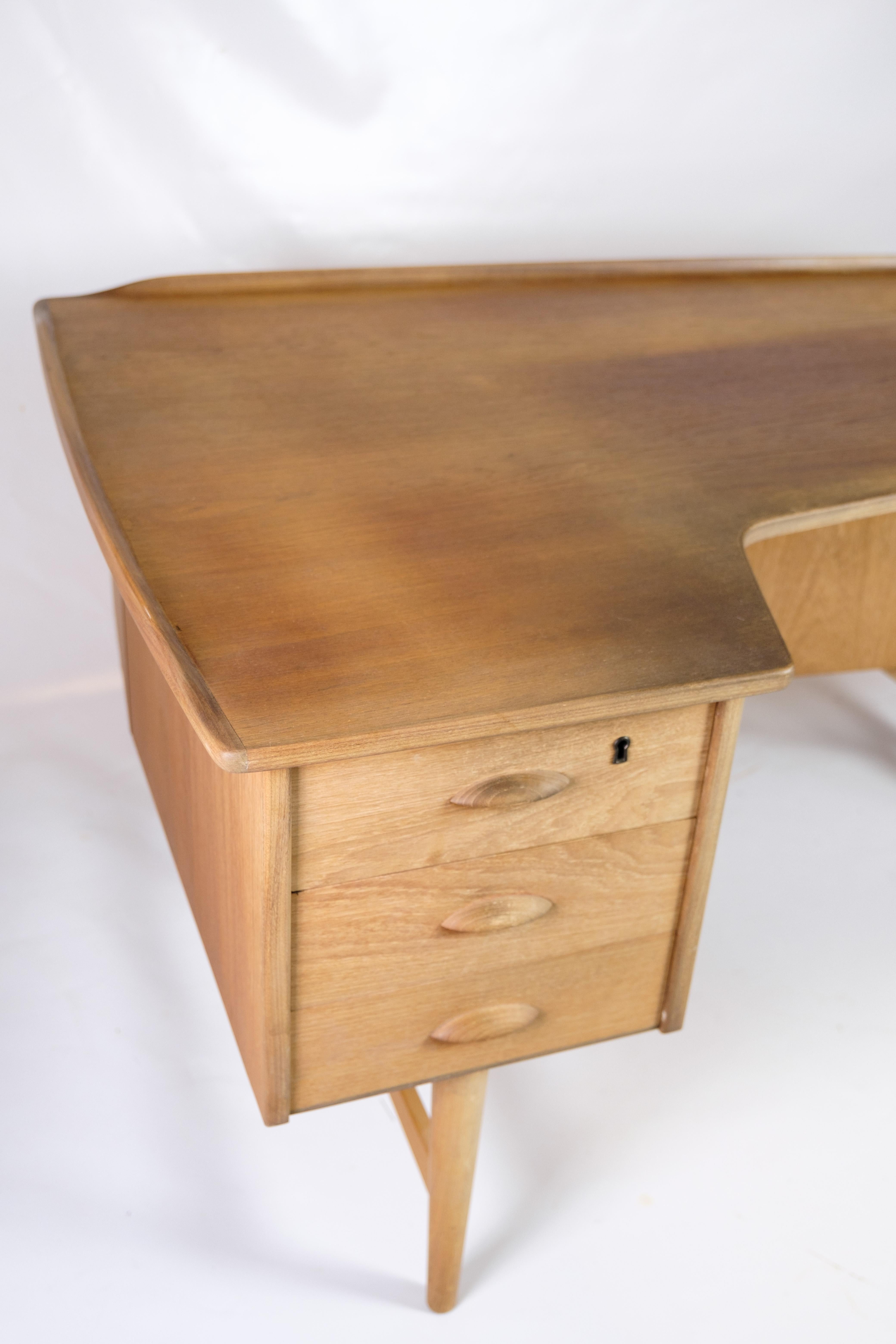 Scrivania Boomerang progettata da Peter Løvig Nielsen nel 1956 e prodotta da Hedensted Møbelfabrik negli anni Sessanta. La scrivania è realizzata in teak con eleganti dettagli in ottone e presenta un caratteristico piano d'appoggio a forma di