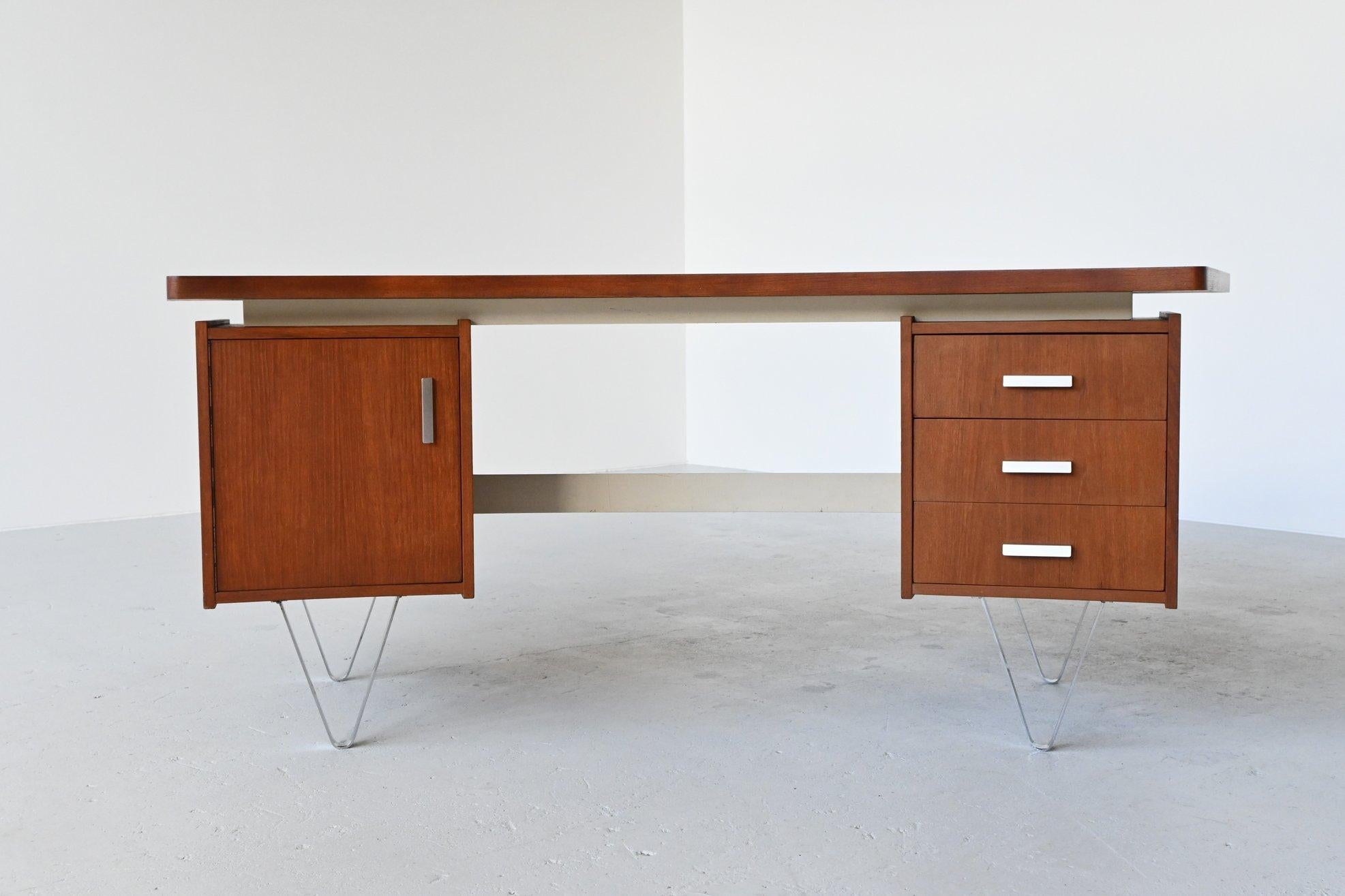 Very nice boomerang shaped floating desk manufactured by Tijsseling, the Netherlands, 1960. This executive desk is often attributed to Cees Braakman for UMS Pastoe. It has 3 drawers on the right and a door on the left with 2 plywood open drawers