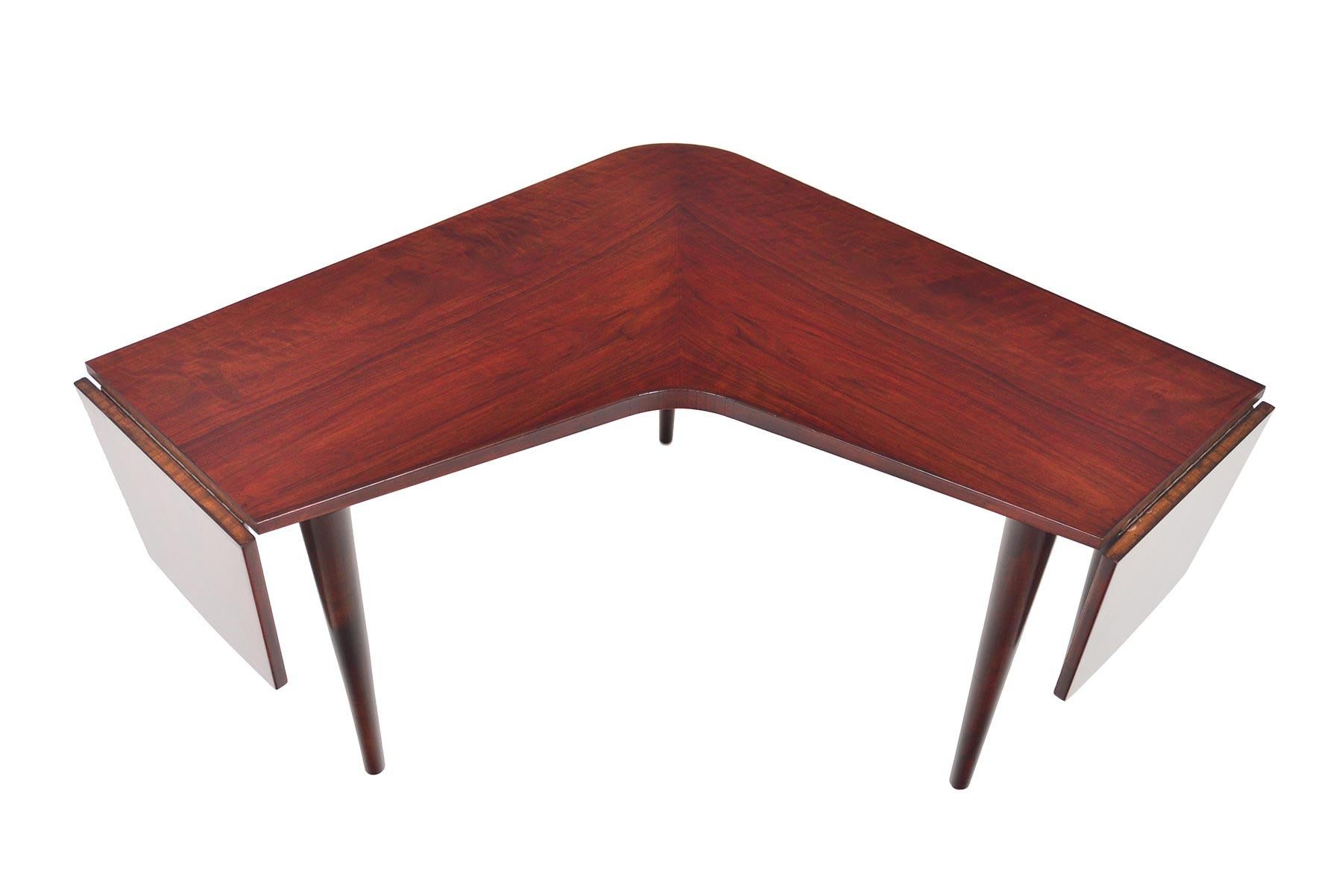 This unusual coffee table was designed by Edvard Valentinsen Møbelfabrik as Model 197 for Series 567 in the 1950s. Beautiful mahogany is formed into a boomerang shape with each end offering a drop leaf extension. Opens to 48