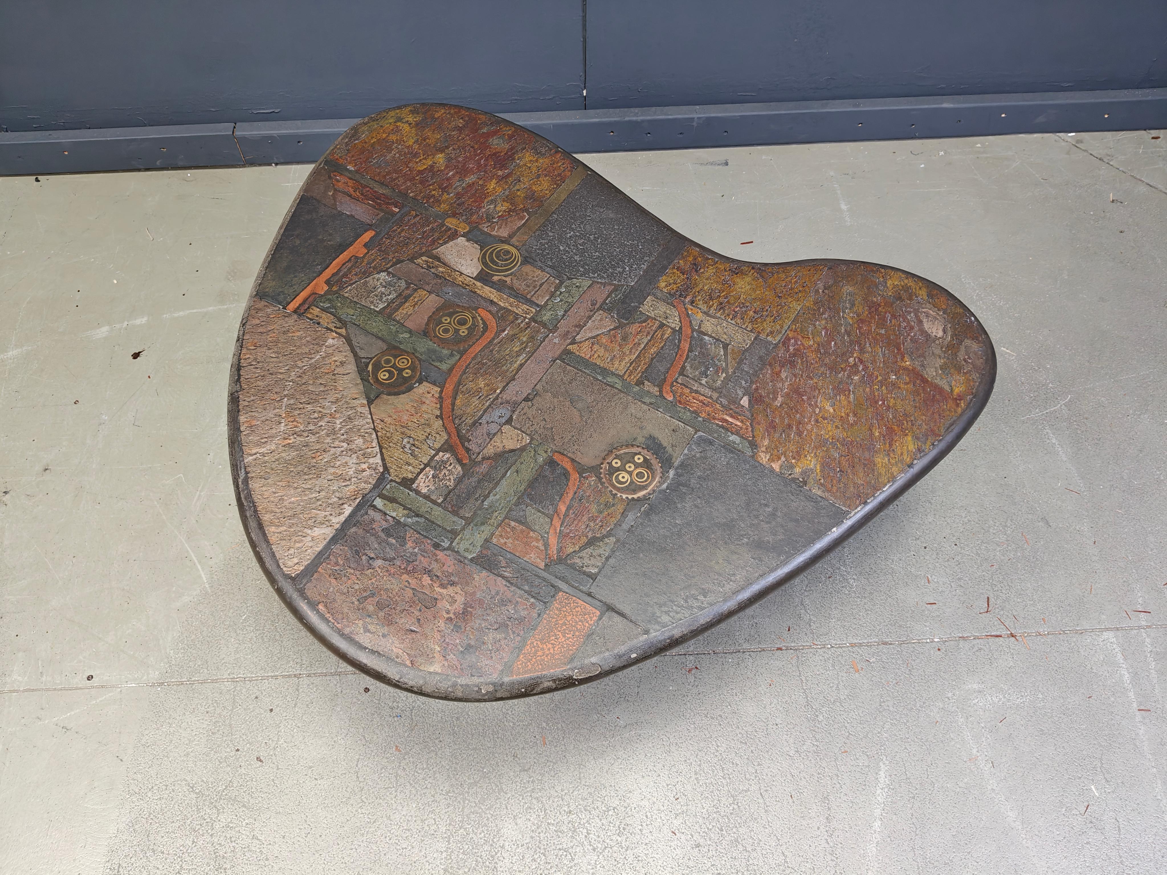 Boomerang shaped brutalist slate stone coffee table in the manner of Marcus Kingma by C. Kneip, 1991

Slate stone table top with inlaid stones and brass materials

1991 - Germany

Dimensions:
Height: 50cm
Width: 80cm
Depth: 95cm

Ref.: