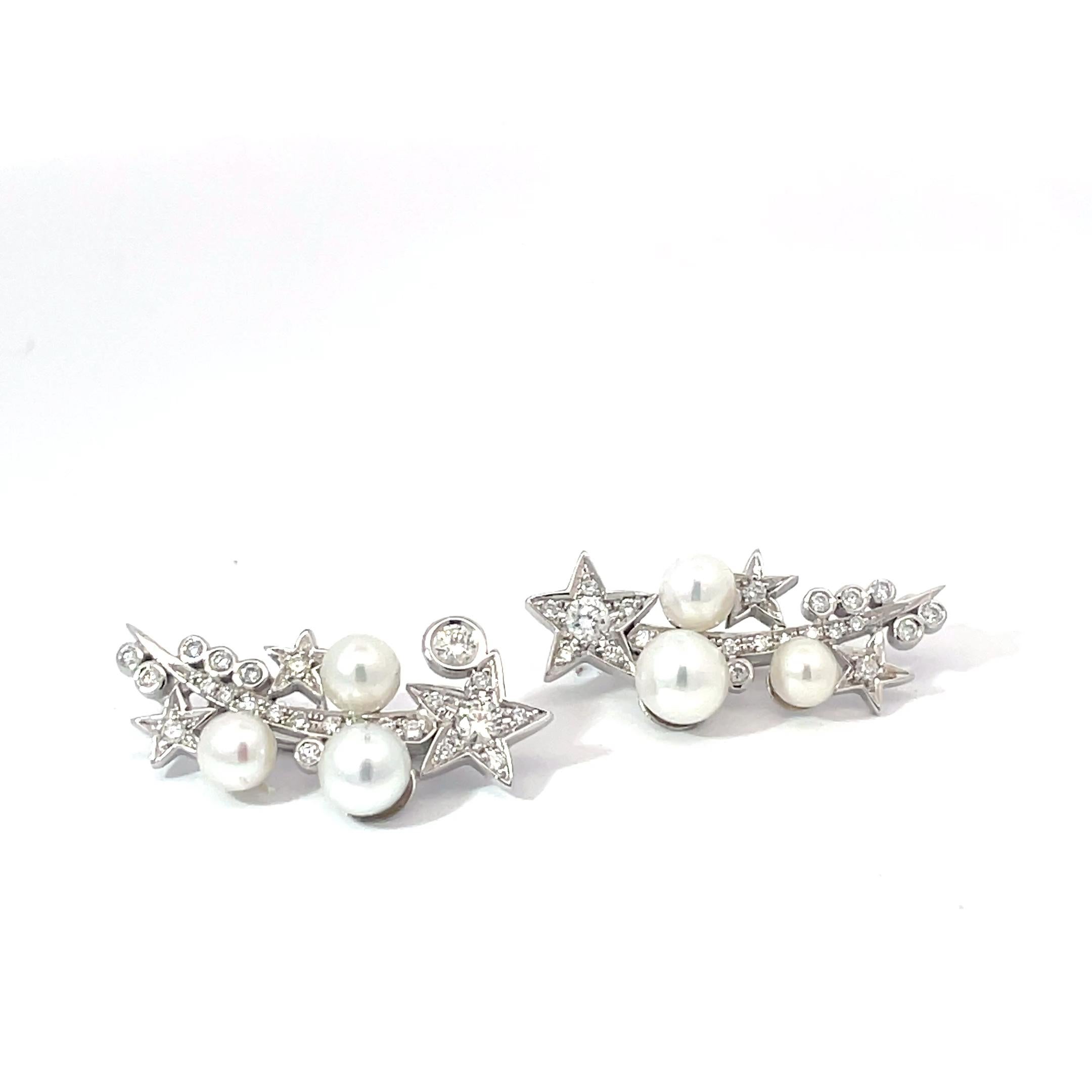 Eleva il tuo stile con questi splendidi orecchini a scalare con stelle e asteroidi realizzati in oro bianco 18 carati. Ornati da perle bianche e charme luminosi, questi orecchini aggiungono un tocco di fascino celestiale a qualsiasi ensemble.