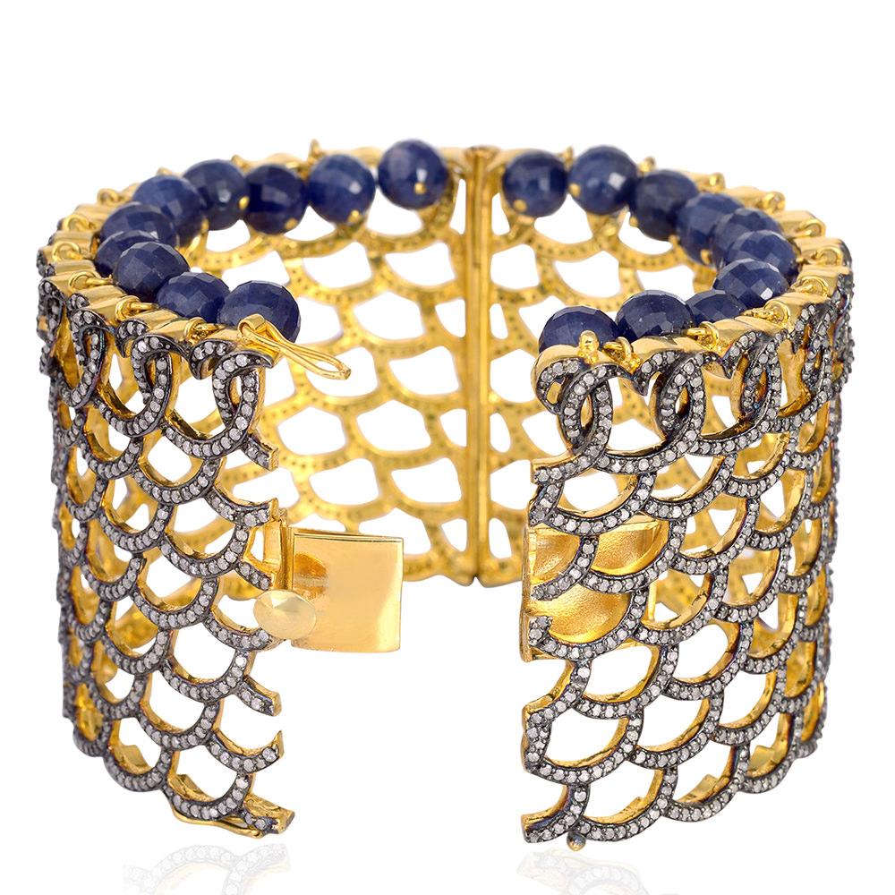 Cast from 18K gold and sterling silver with blackened finish.  Bold and distinctive, a stunning statement cuff set in 103.8 carats blue sapphire & 13.26 carats of diamonds. Pair this with your favorite evening dress for a red carpet look. Clasp