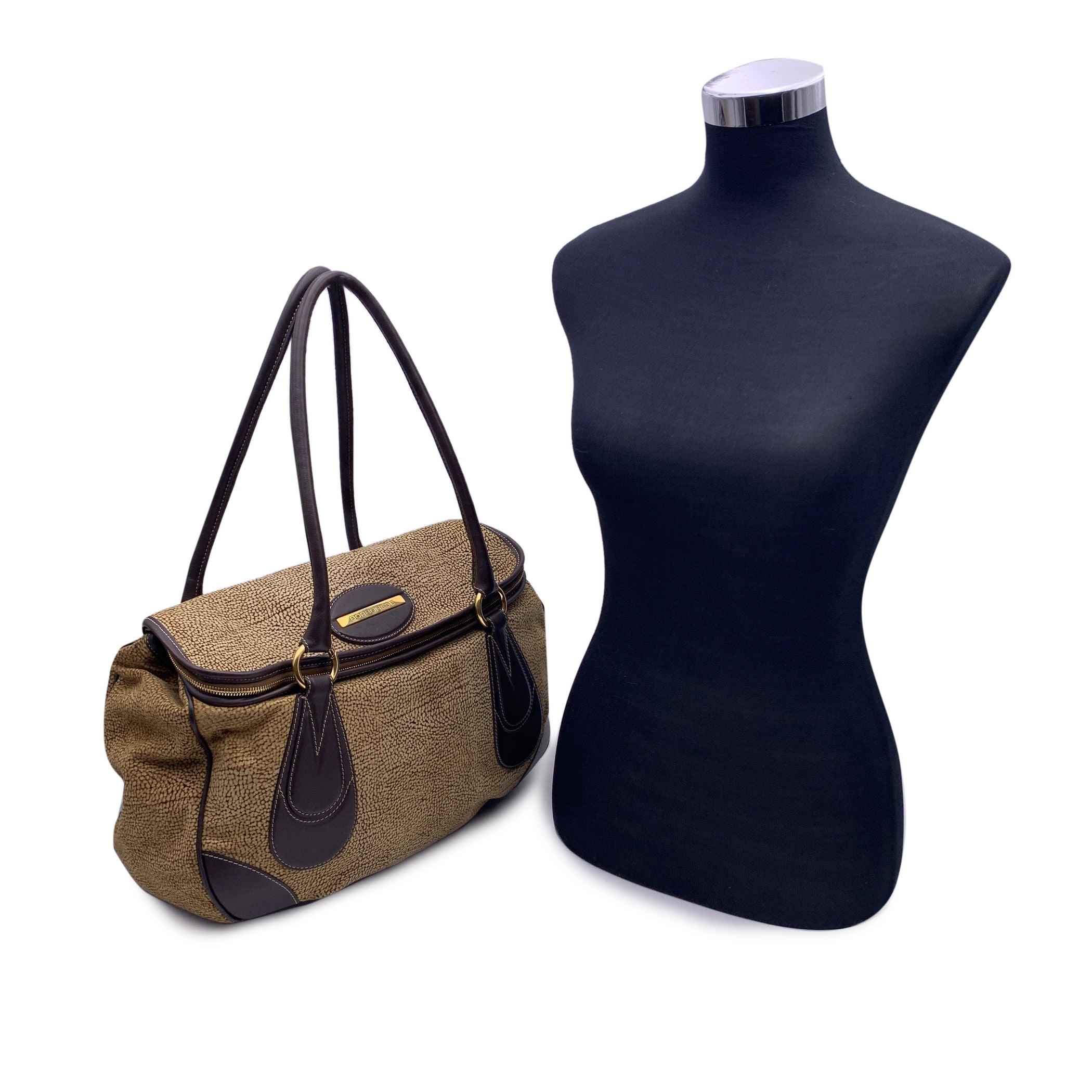 Beautiful Borbonese tote shoulder bag in brown Op suede with brown leather trim and shoulder straps. Flap with zip compartment. Magnetic button closure. Gold metal hardware.Brown fabric lining. 1 side zip pocket inside. 'Borbonese' tag inside