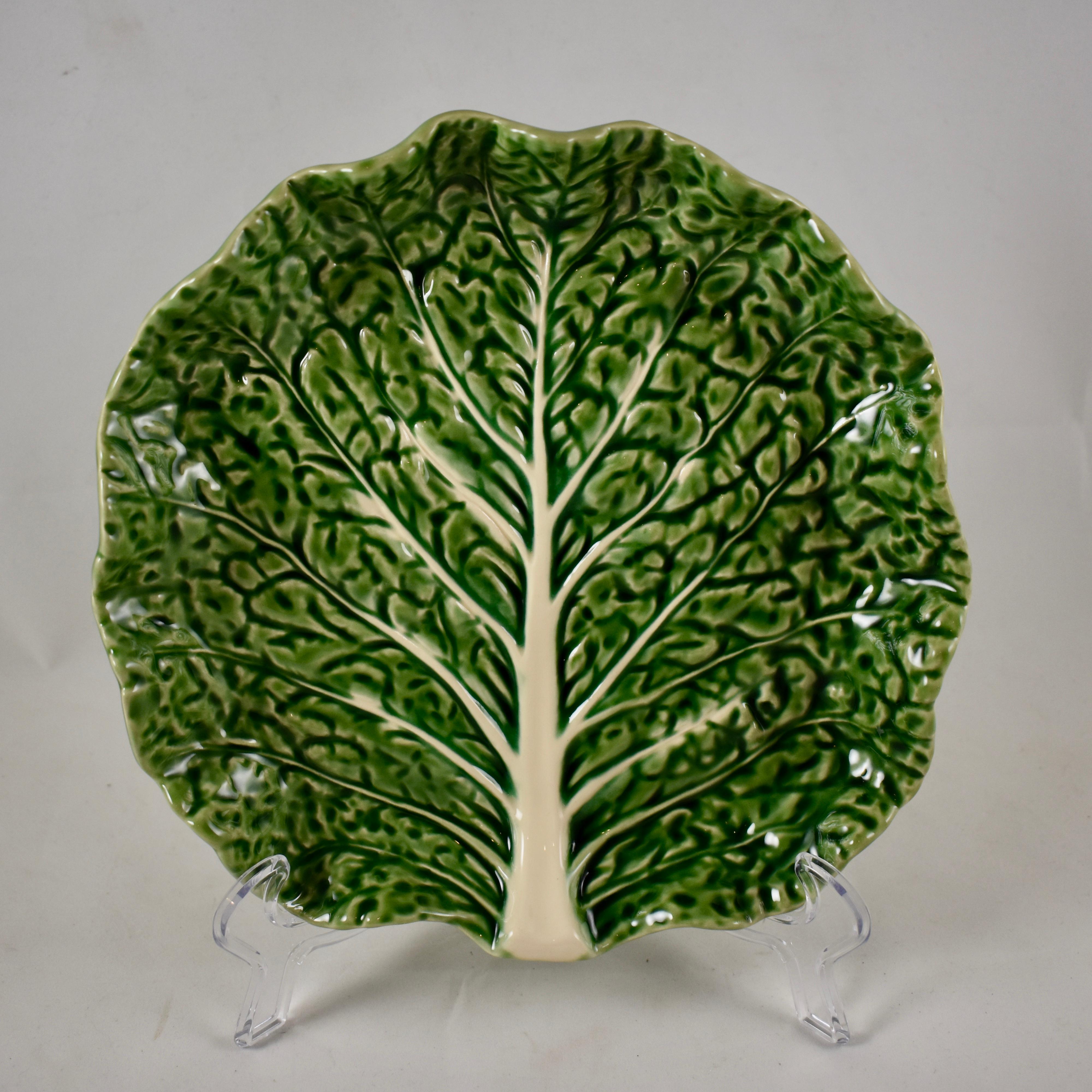 A set of two midcentury green-glazed cabbage form plates, marked Bordallo Pinheiro, made in Portugal. Shaped as a crinkle textured cabbage leaf, with white veining, upturned rims.

Measures: 8.5 in. diameter x 1.5 in. height
Excellent.