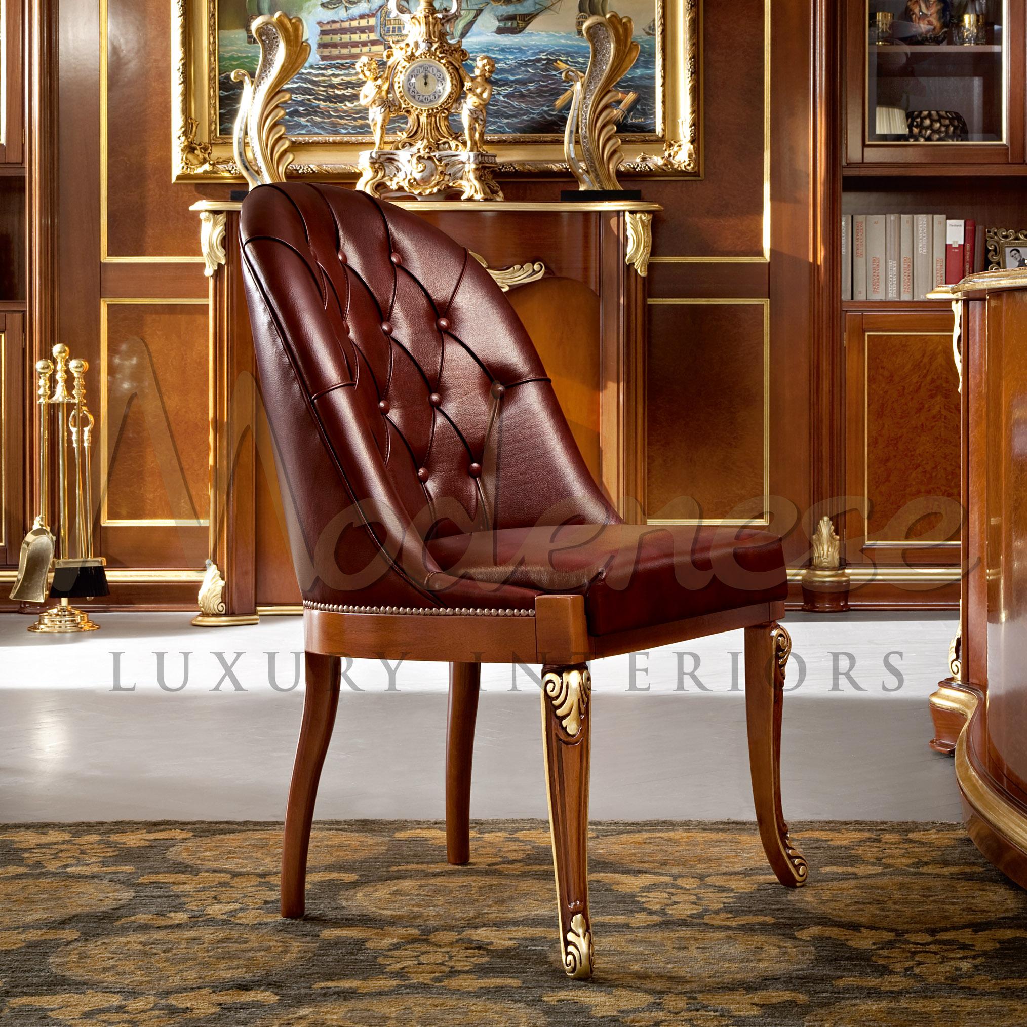Lassen Sie Ihre Gäste auf diesem bordeauxfarbenen Bürostuhl aus echtem Leder von Modenese Luxury Interiors Platz nehmen, der mit einer Capitonne-Rückenlehne und Blattgoldschnitzereien verziert ist. 
Dieses Stück ist Teil des maßgeschneiderten