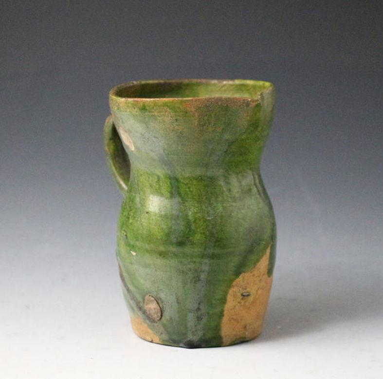 A good Border Ware pottery rounded drinking jug with well applied green glaze. 

Surrey-Hampshire Border ware ceramics (hereinafter called Border ware) were produced 
during the sixteenth and seventeenth centuries along the border of north-east