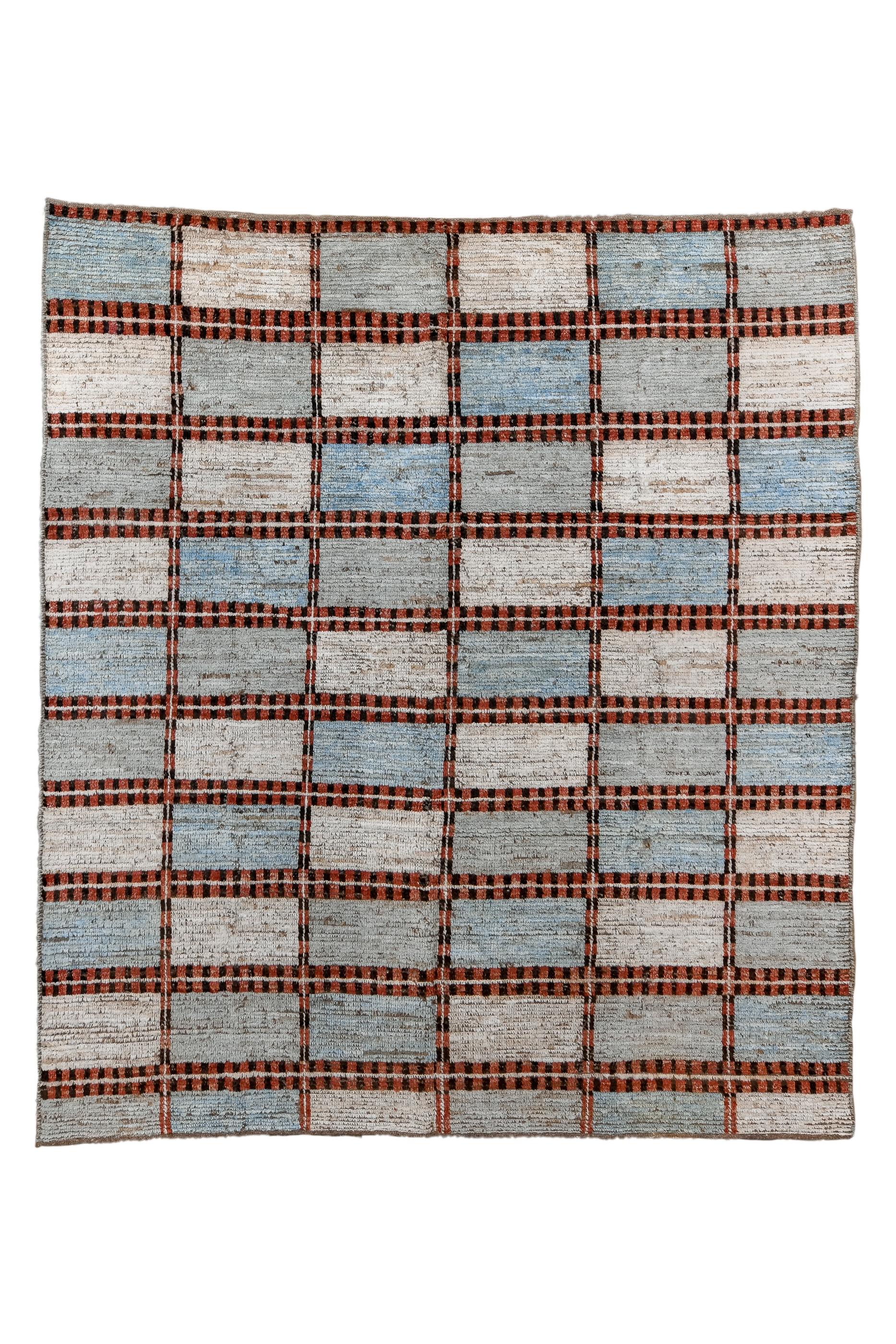 This innovative long pile, coarse weave carpet shows a six by ten gridwork of rectangles in abrashed pastels of blue and beige. A double bar framework holds it all in place.  No real end or side borders. Wool foundation. Coarse weave with wefts very