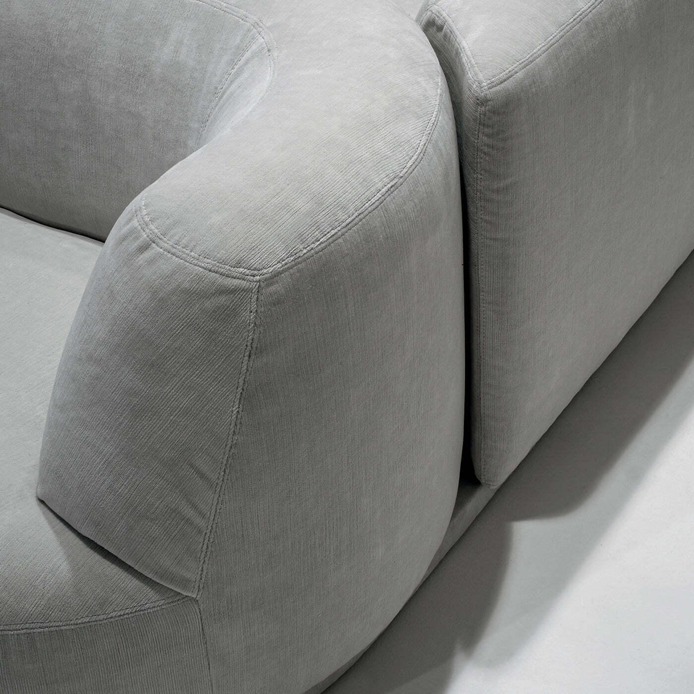 Modular, original, and sophisticated, this exquisite sofa boasts a stunning modular shape comprised of a side armchair and an opposing pouf, complementing the central sofa-like module. Available in other modules that can be found in the Artemest