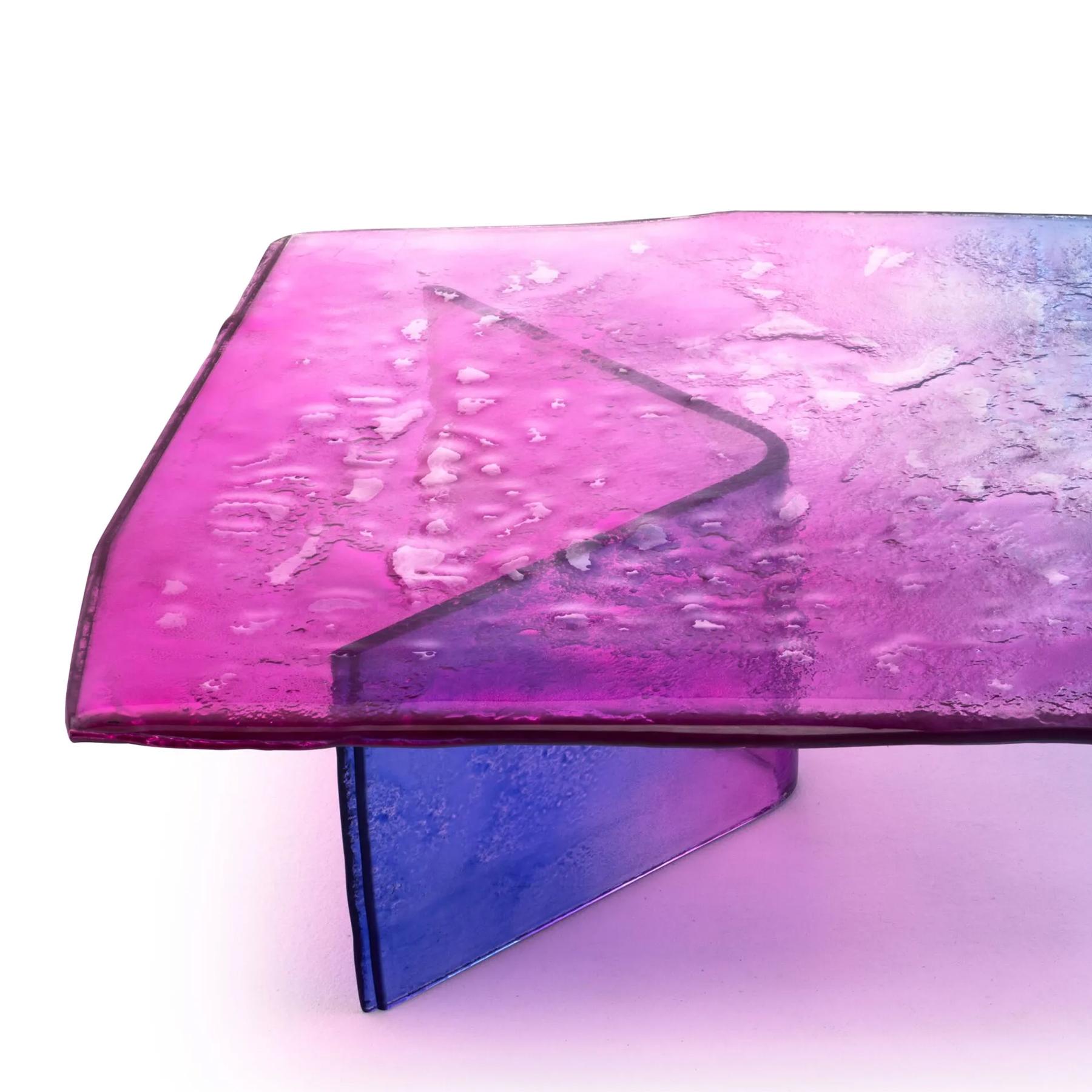 Mesa de centro Borealis con patas y tablero de cristal horneado 
en dos capas. Tablero con bordes irregulares. Toda la pieza 
está barnizada en gradación de azul a rosa, con suave
plateado parcial en el dorso. 