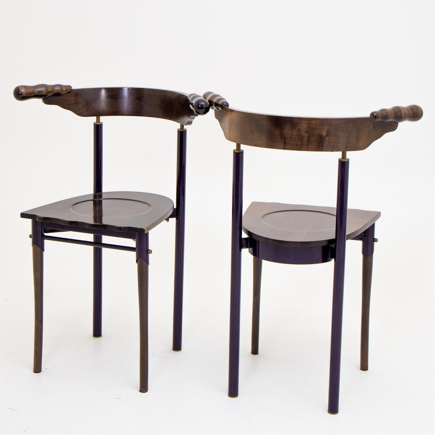 Two designer chairs designed by Borek Sipek for Driade in Italy. The backrest, seat and front legs are made of wood, and the metal frame appears deep purple in most lighting conditions. The rounded backs end in organically shaped knobs and the seat
