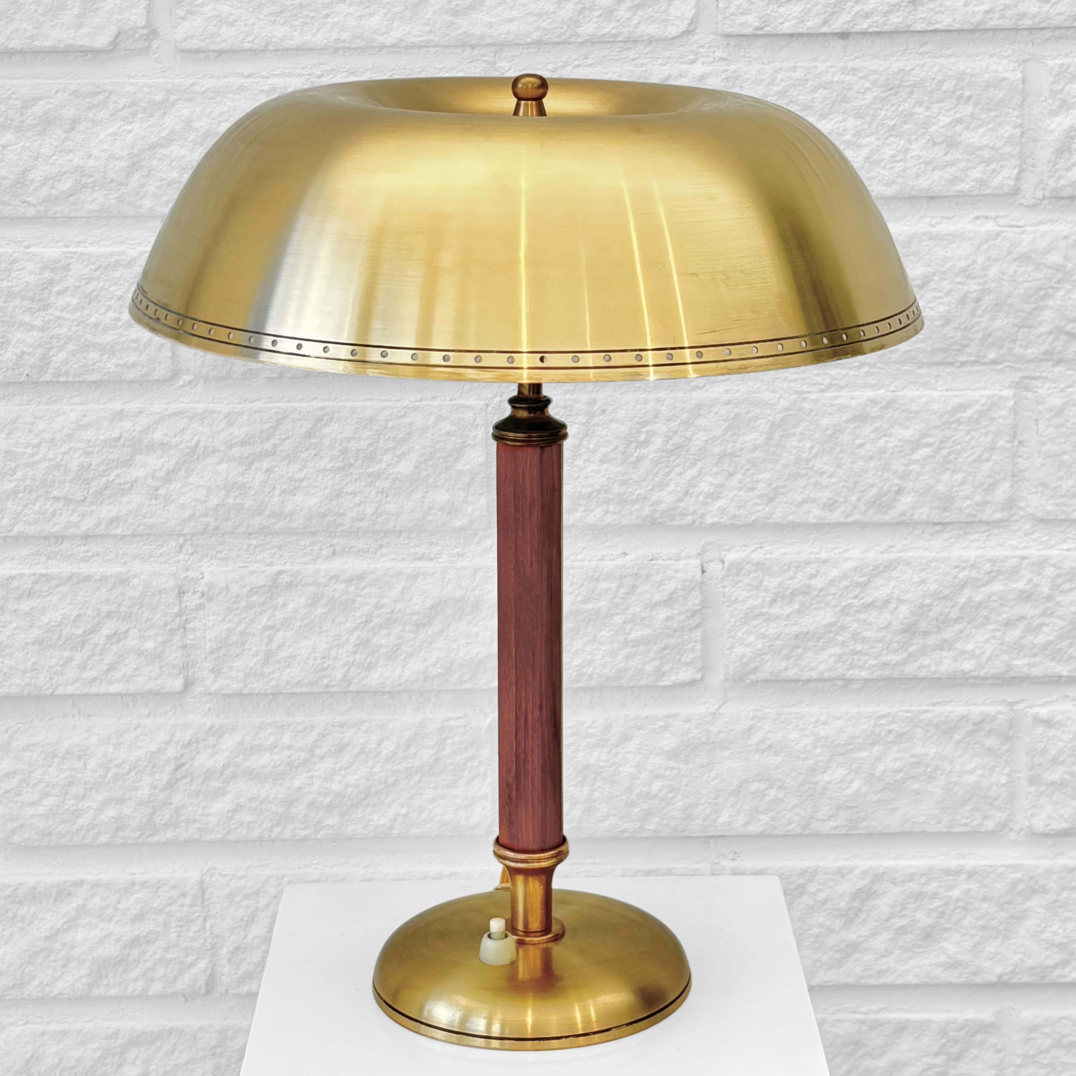 Una elegante lámpara de mesa modernista sueca, modelo 8451, producida por el fabricante Boréns en la década de 1940. Fabricada en latón, presenta una pantalla superior en forma de cúpula con puntos perforados en el borde, apoyada en un pilar