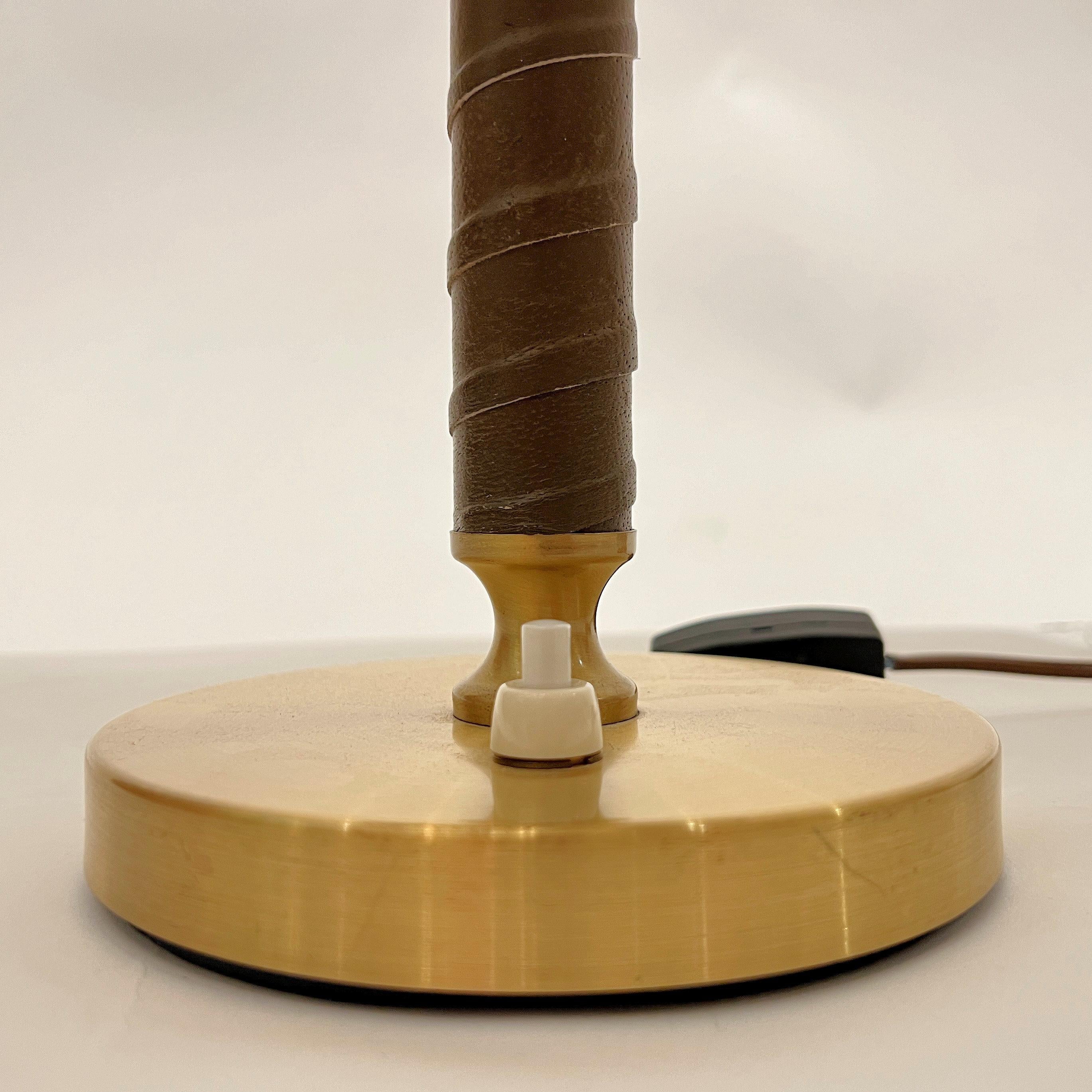 A Swedish Modern table lamp by Swedish Manufacturer Boréns. With brushed brass shade and custom finial, and a leather wrapped stem. Includes new wiring. Circa 1970s. 