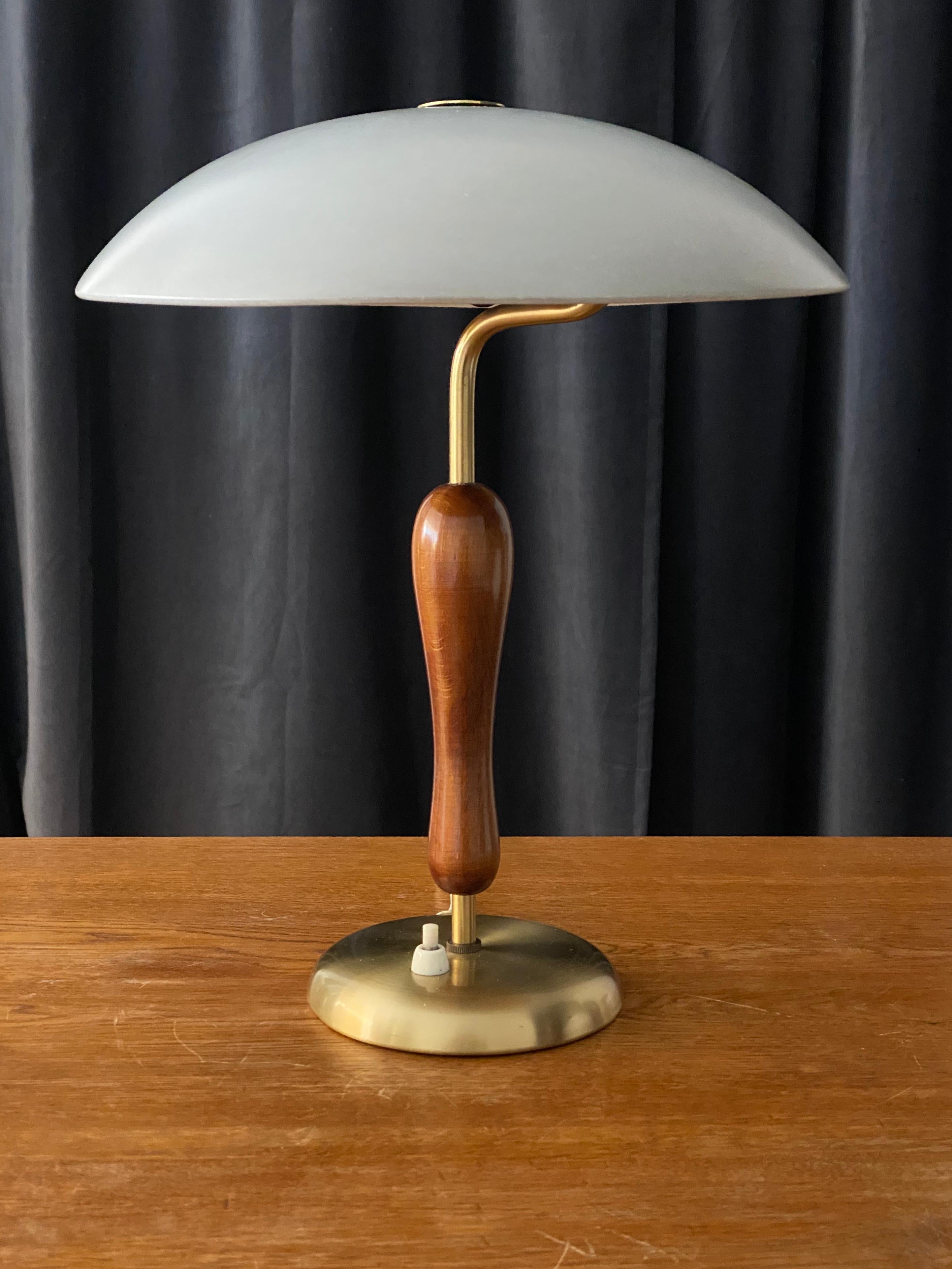 A modernist table lamp. Produced by Boréns, Borås, Sweden, late 1940s.

Features a finely sculpted lacquered wood handle on a brass rod and base, original lacquered metal screen.

Other designers of the period include Paavo Tynell, Lisa
