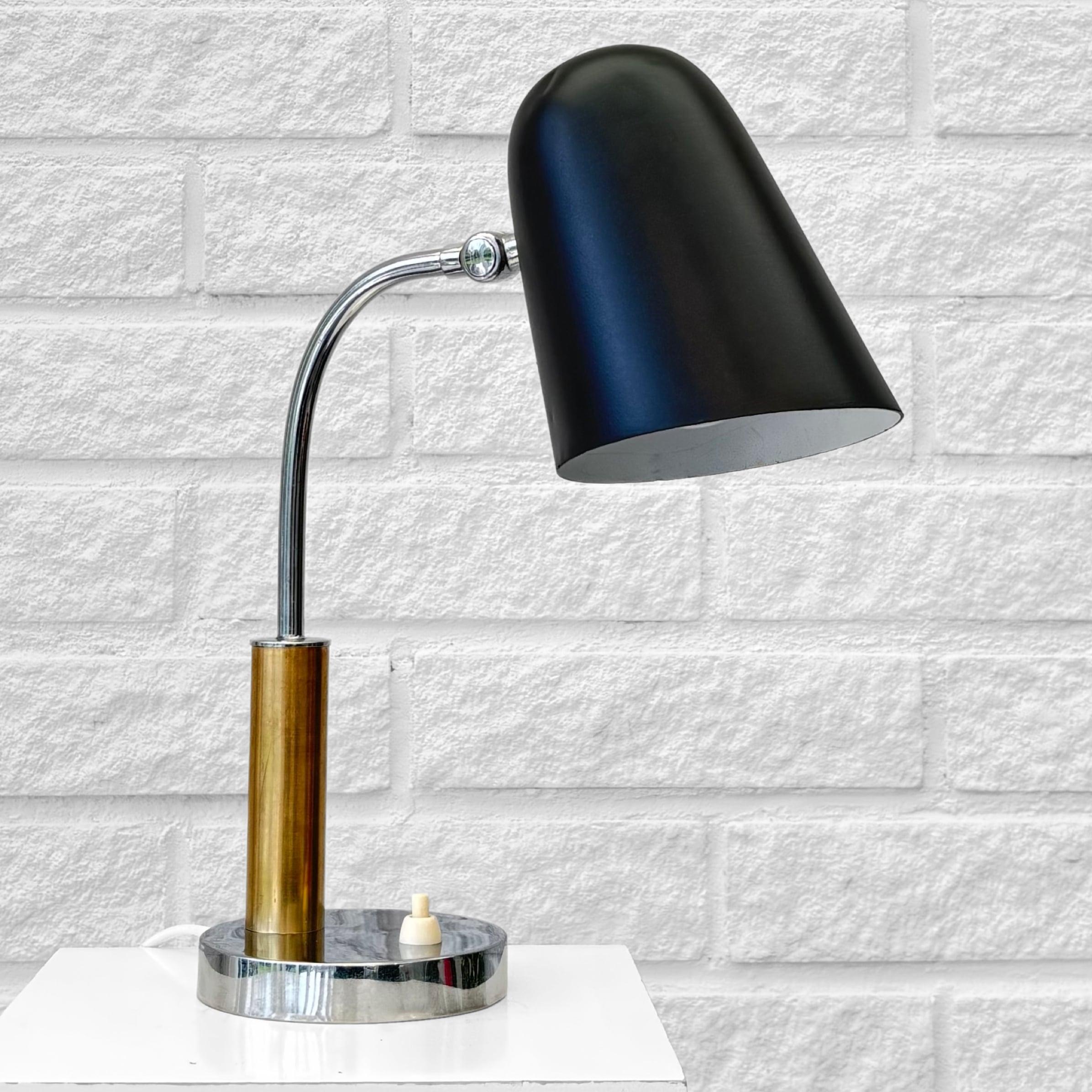 Lámpara de mesa moderna escandinava modelo 503, producida por el conocido fabricante sueco Boréns en la década de 1940. Fabricada en latón y acero cromado con una pantalla ajustable de metal negro. Pie circular con interruptor de luz