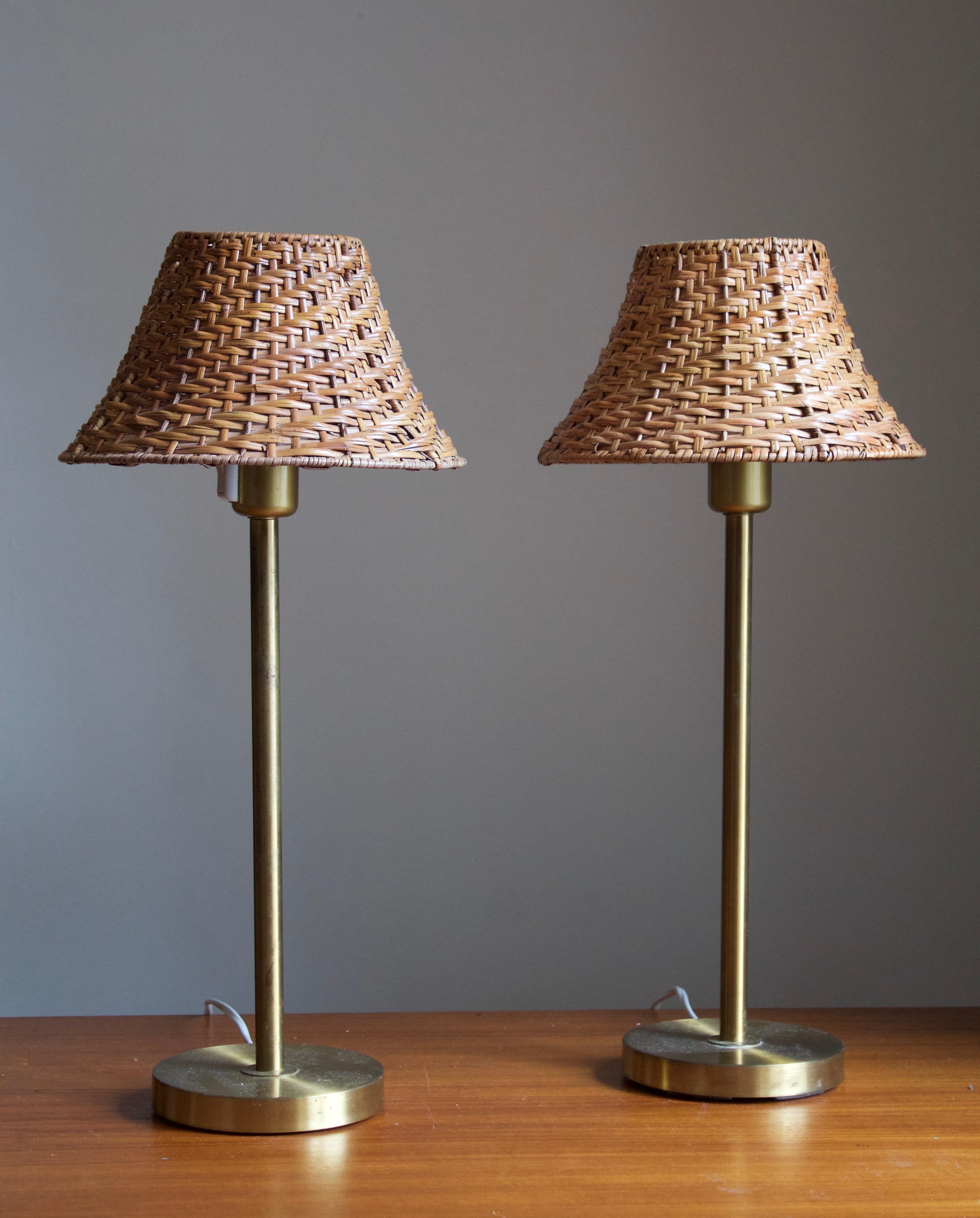 A pair of table lamps of pure and simple form and execution. Designed and produced by Boréns, Borås, Sweden, c. 1970s. 

In brass, sockets in brass-colored plastic. 

Stated dimensions exclude lampshades. Upon request illustrated vintage rattan