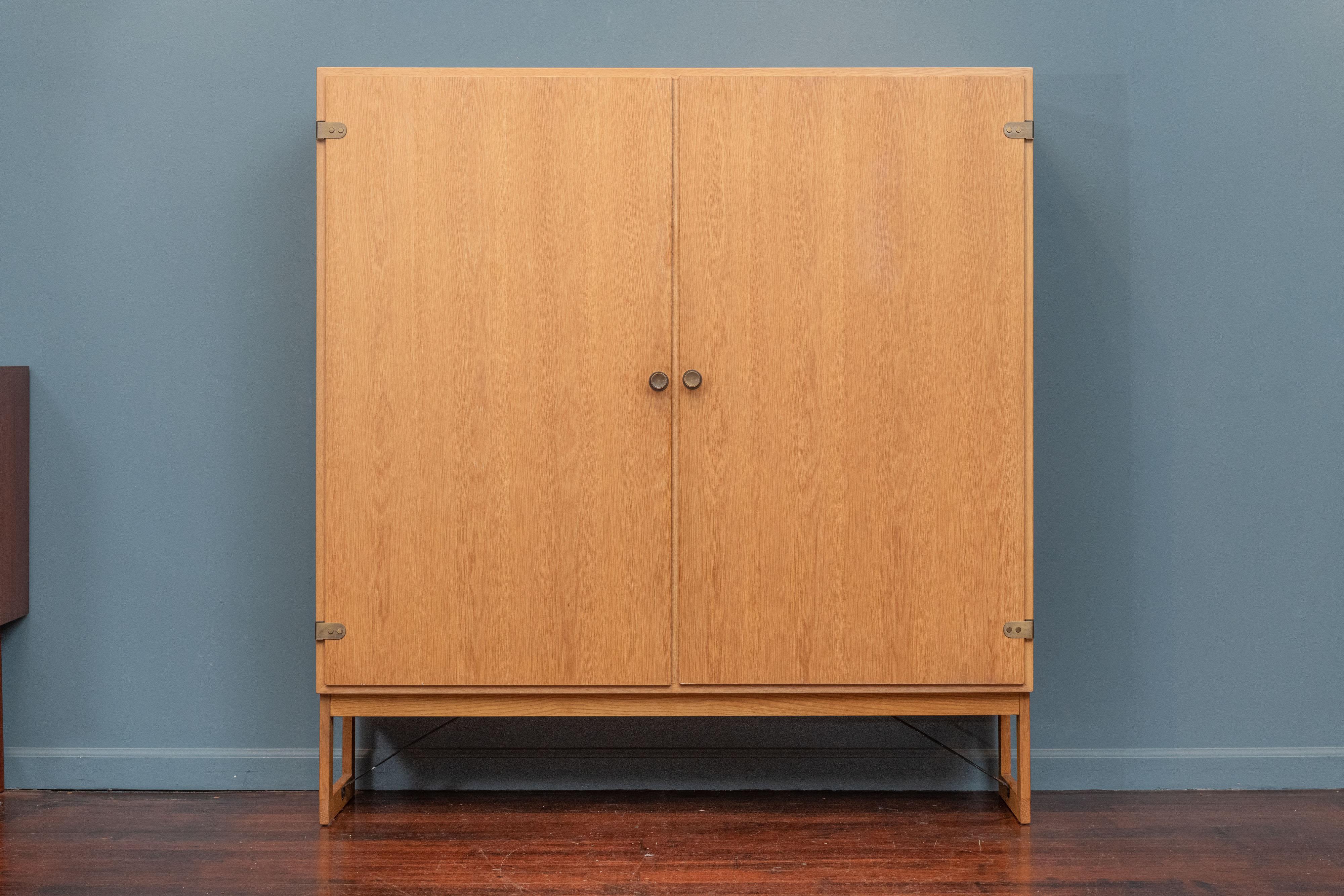 Borge Mogensen design large cabinet for Karl Andersson & Soner, Denmark. High quality construction and materials with elegant brass hardware and steel strap supports. Adjustable shelves that could be used for multiple purposes and ways, ready to