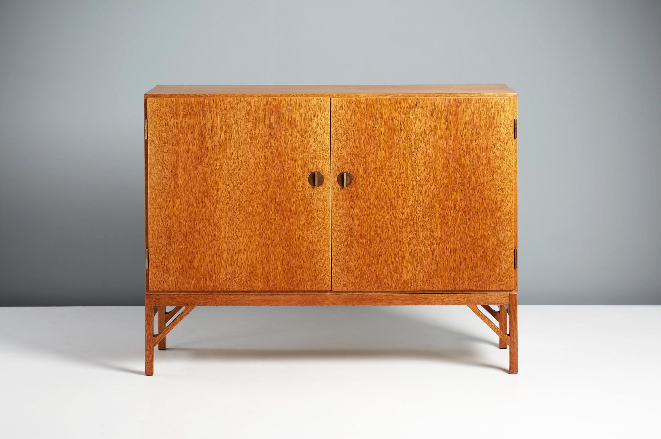 Borge Mogensen - Model A 232 Cabinet.

Mogensen's iconic cabinet design: The front has two doors with Chinese style decorative brass T-Bar keys. The interior is lined with Maple wood veneer and solid maple shelves and trays. Superb condition and