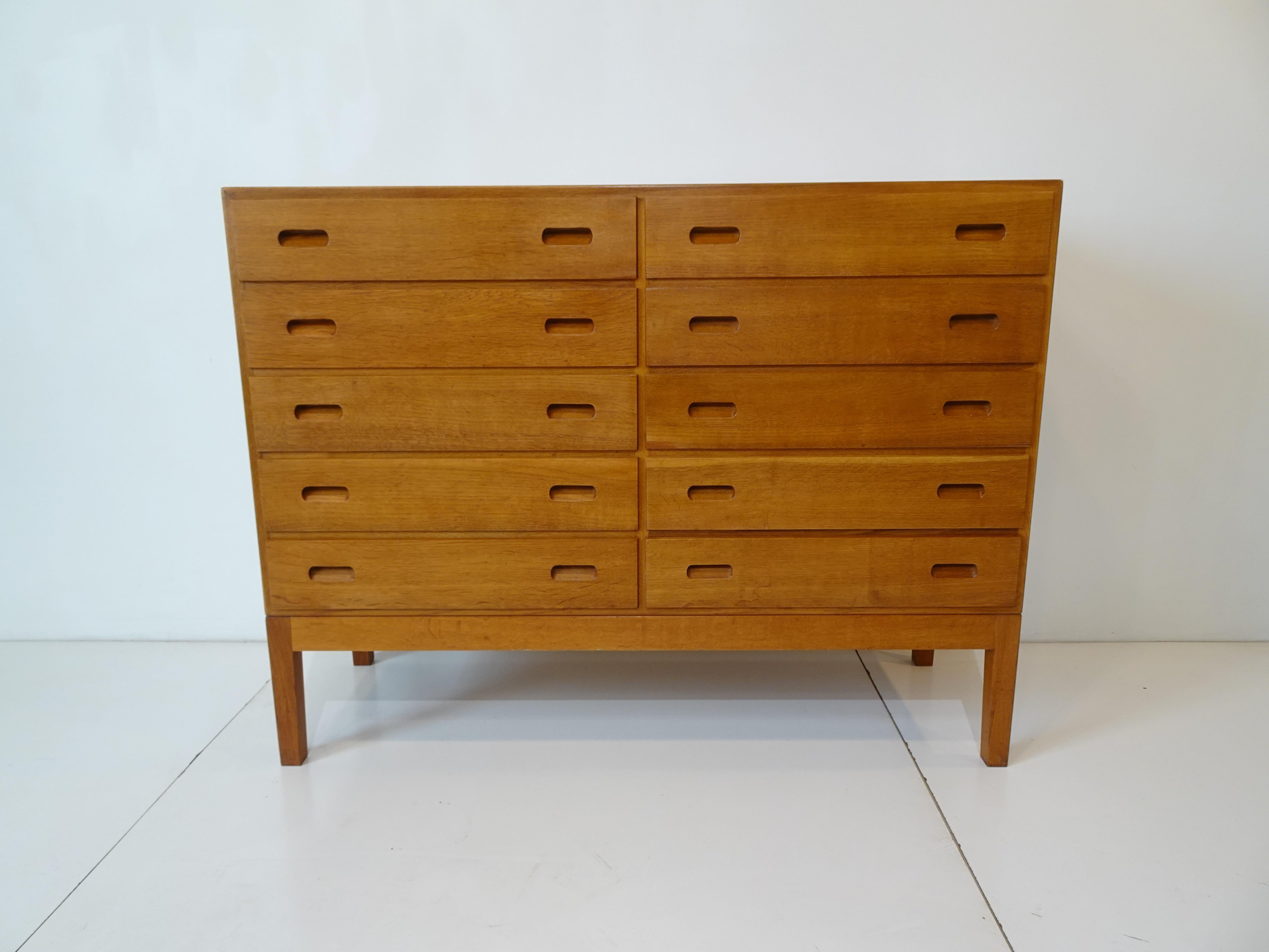 A very well crafted rare ten drawer dresser chest with inset pulls to the fronts all in Scandinavian oak sitting on square frame and legs having plenty of storage . Designed by Borge Mogensen retaining the ink stamps to the backside constructed by