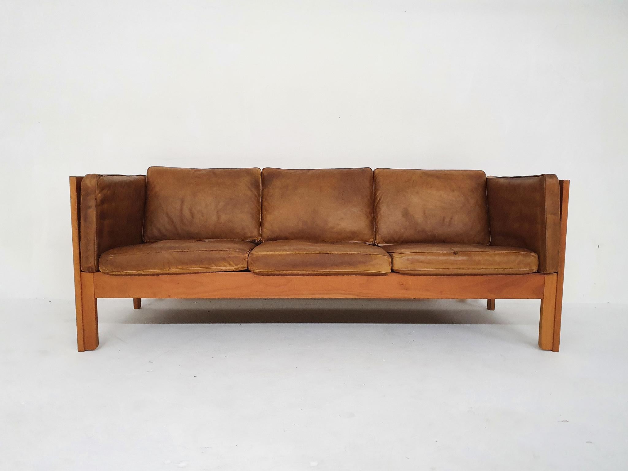 Wooden sofa with cognac leather cushions. Designed by Borge Mogensen for Fredericia.
The leather has some stains and the arm rest cushion has cat scratches. The wooden frame is in good condition, only a sratch on the back.
The sofa is marked