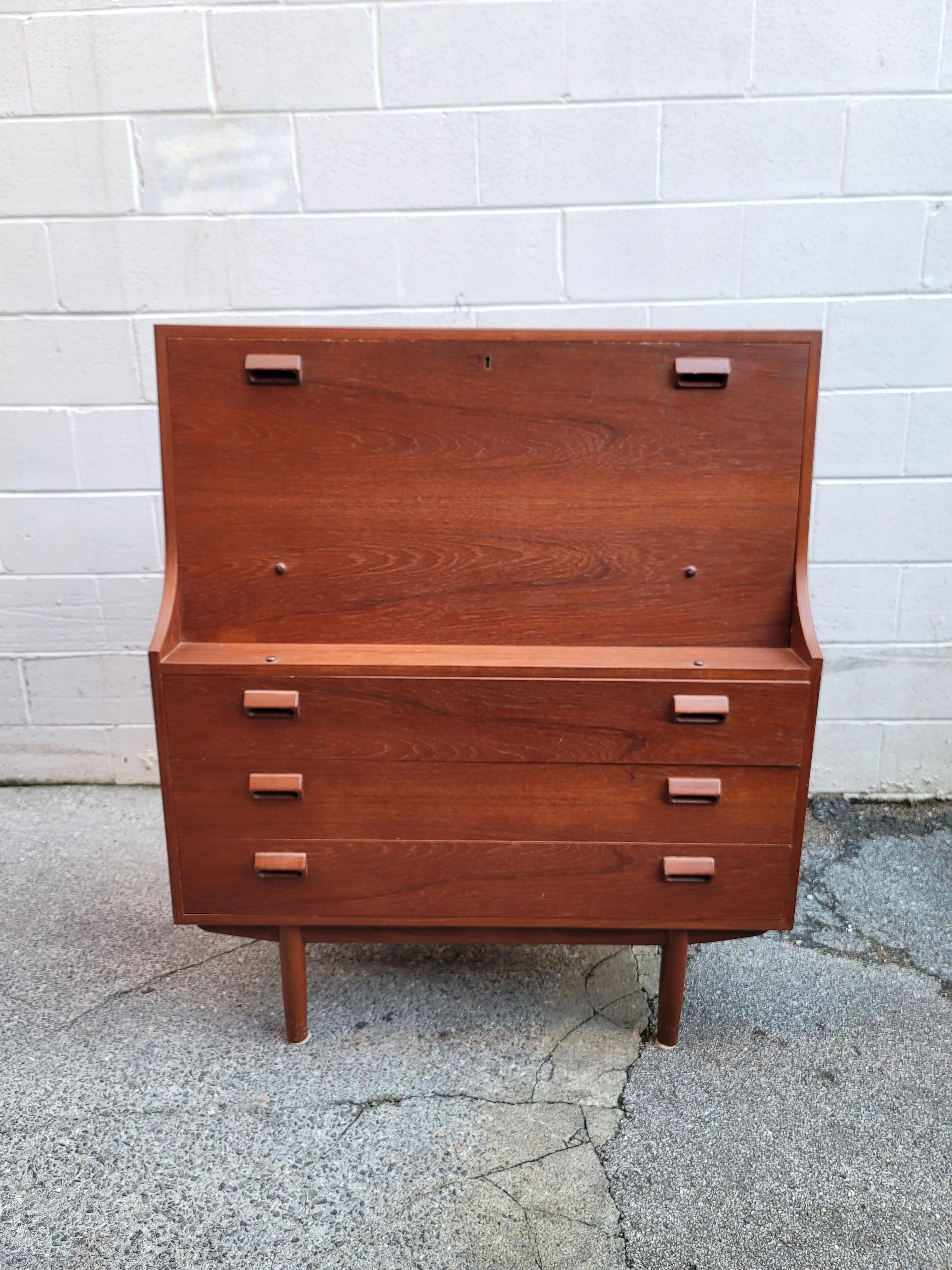 This Danish Modern secretary desk was designed by Borge Mogensen for Soborg Mobelfabrik. Purchased from the original owners family, this desk is in beautiful condition with very little signs of wear or use. The teak has the hallmark deep red of