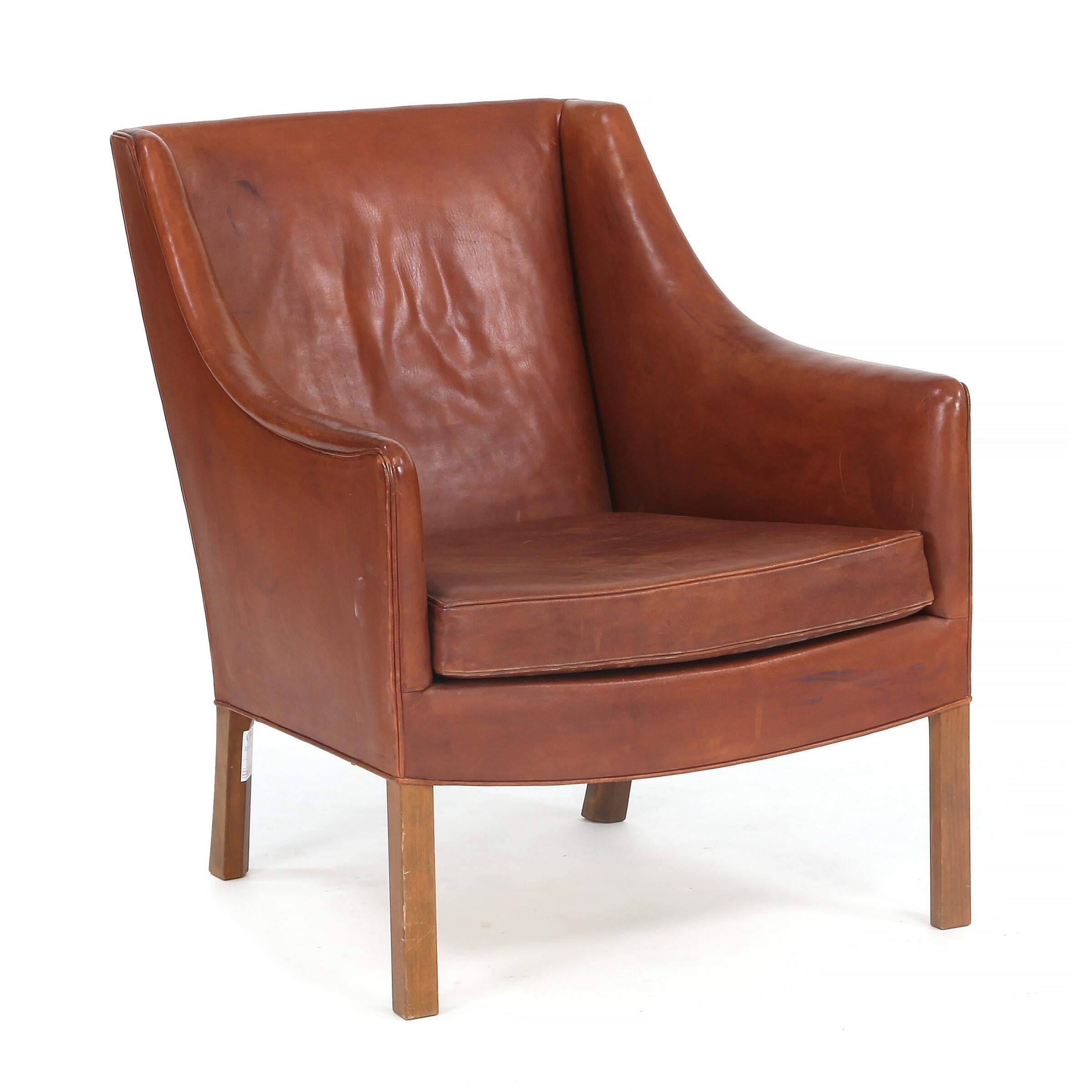 This armchair was designed by Borge Mogensen and made and labeled by Johannes Hansen during the 1960s. The chair retains it original brown leather in good condition with normal signs of use. Not many of this chair were made. 

Similar in design to