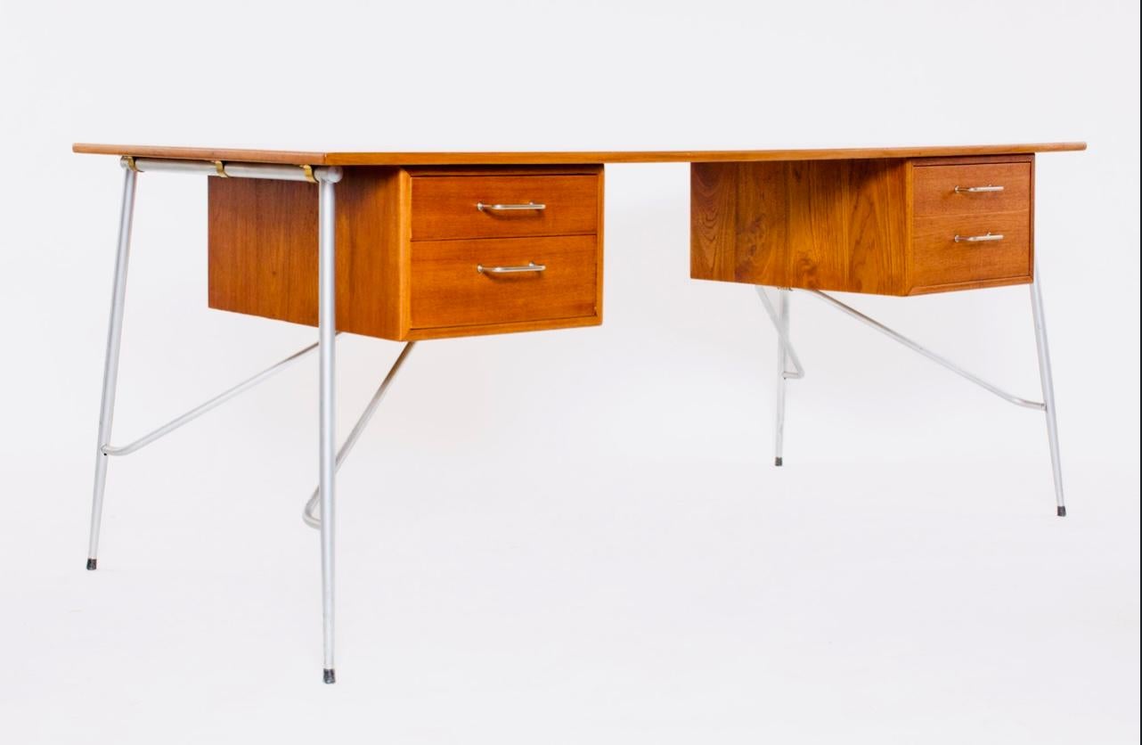 A rare teak desk model
202 with brushed steel legs and 4 drawers.

This minimalist designed desk was created by the father of modern minimalism Børge Mogensen in 1953 and it has stood the test of time and daily use.

The desk stands on very