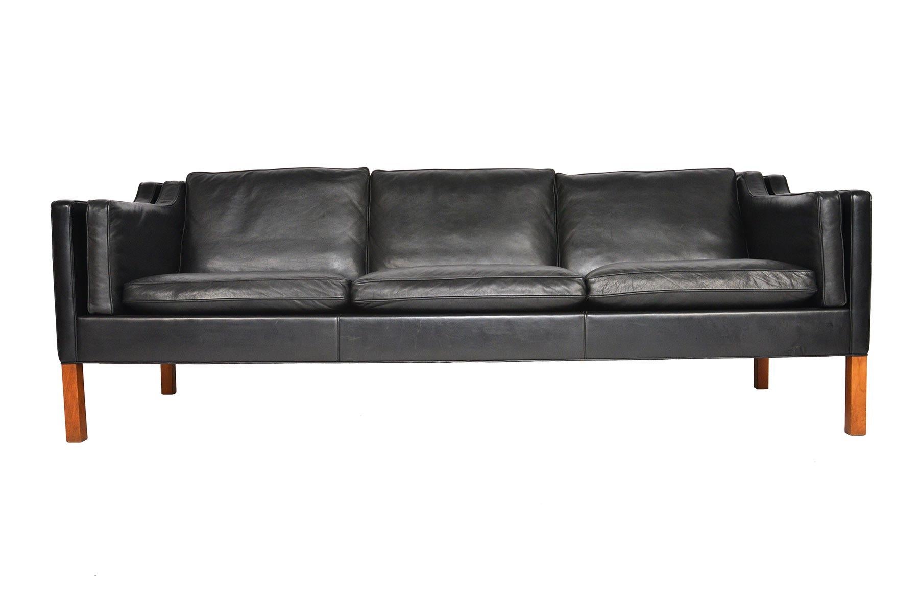 This Danish modern midcentury model 2213 three seat black leather sofa was designed by Børge Mogensen for Frederica Furniture. A staple of modern decor, this piece set a new standard for simplistic, timeless design. This completely original sofa is