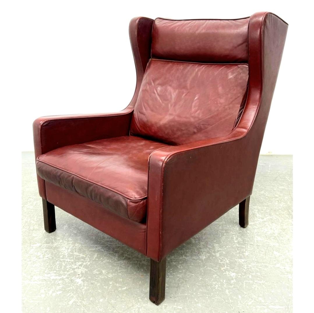  Leather lounge chair in rare red colored leather and beech wood, with shelter back and sloped track arms by Borge Mogensen. Danish, c. 1960's-1970's. 
 With gently sloping track arms, austere and refined silhouettes. This lounge chair finished in