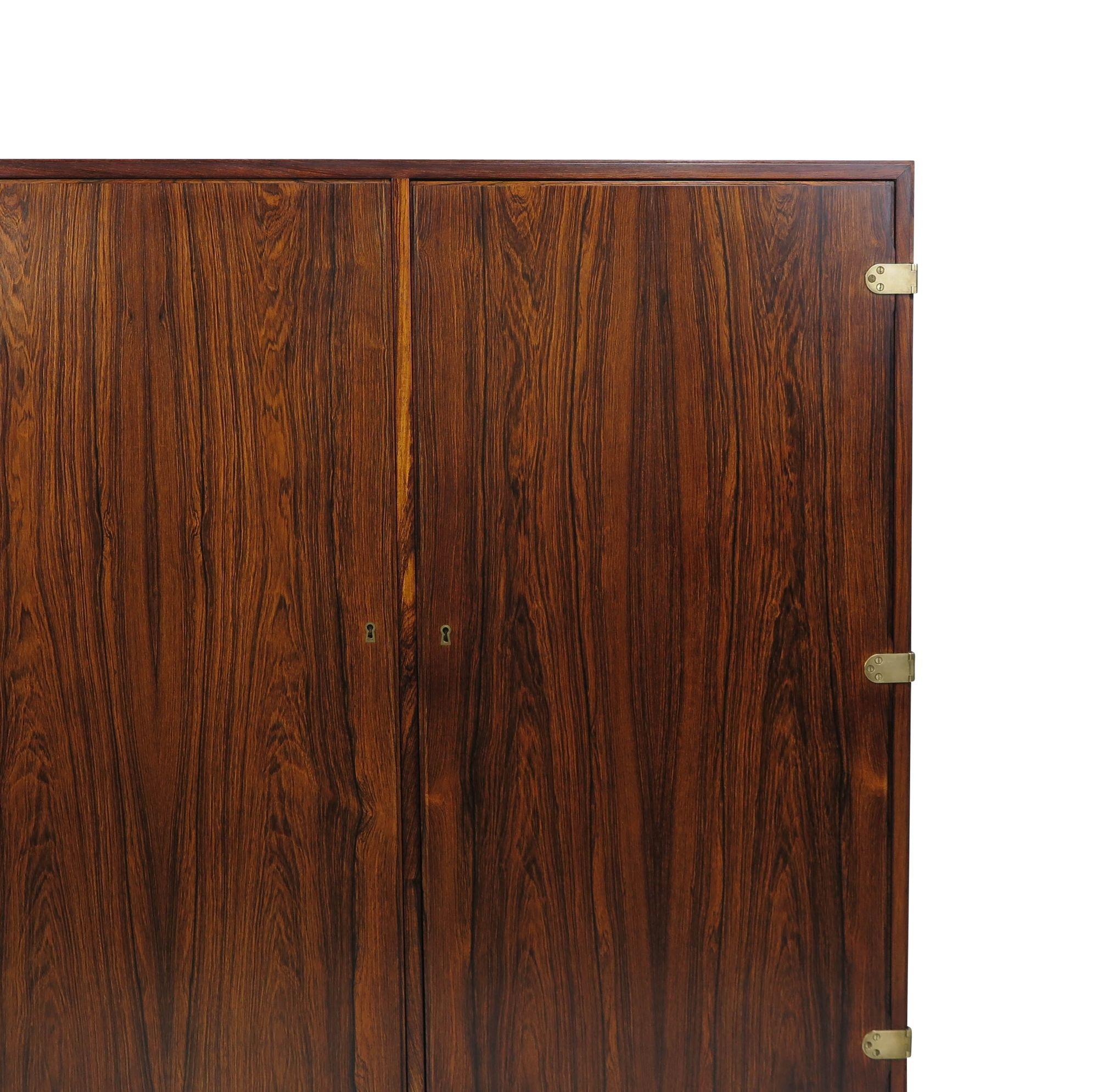 Scandinavian rosewood bar cabinet designed by Børge Mogensen, Denmark, 1948. This handcrafted Brazilian rosewood cabinet showcases meticulous attention to detail with its mitered edges and two locking doors adorned with brass hinges and key. Opening