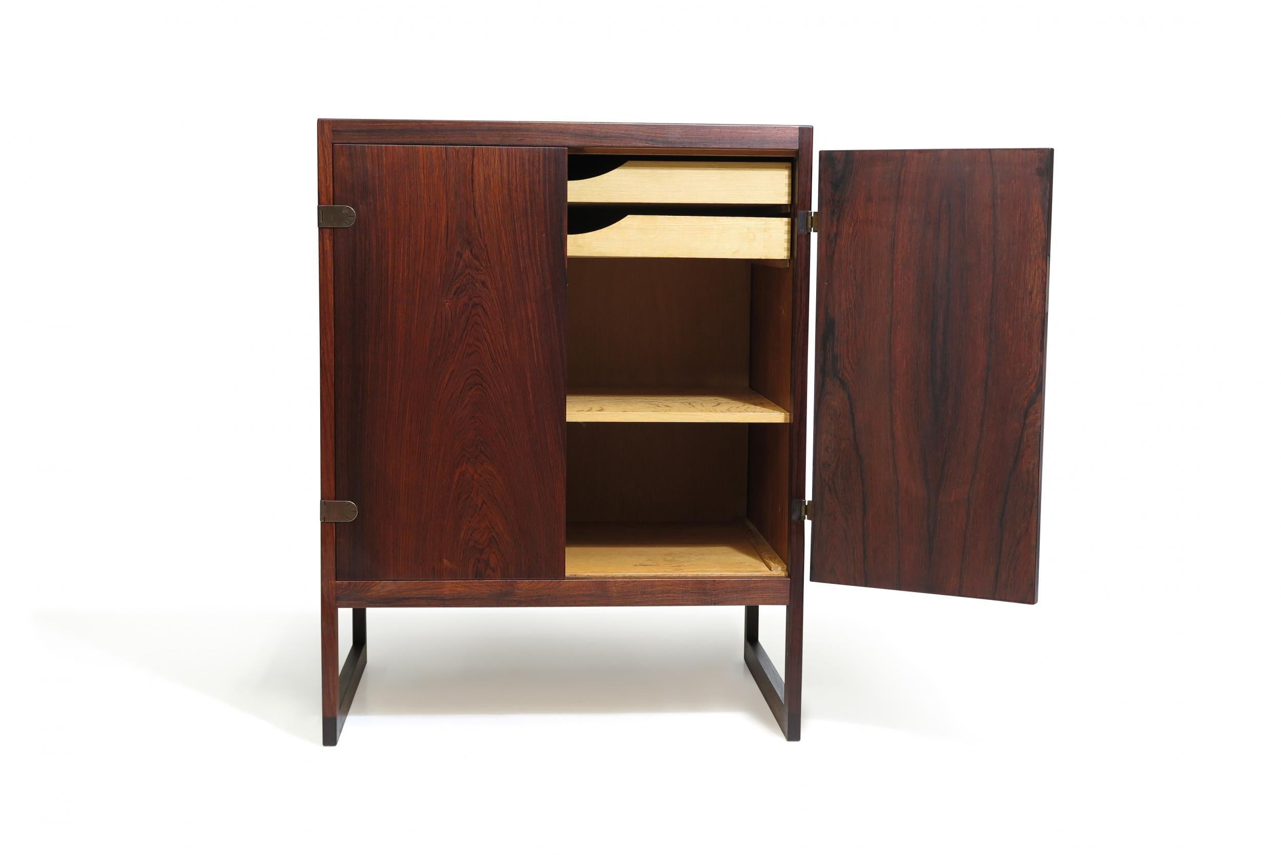 Scandinavian rosewood cabinet designed by Borge Mogensen for P. Lauritsen & Son Denmark, Model BM 57. Cabinet crafted of rosewood with two doors with brass hinges and key. Interior of white oak with series of small drawers and adjustable shelves.