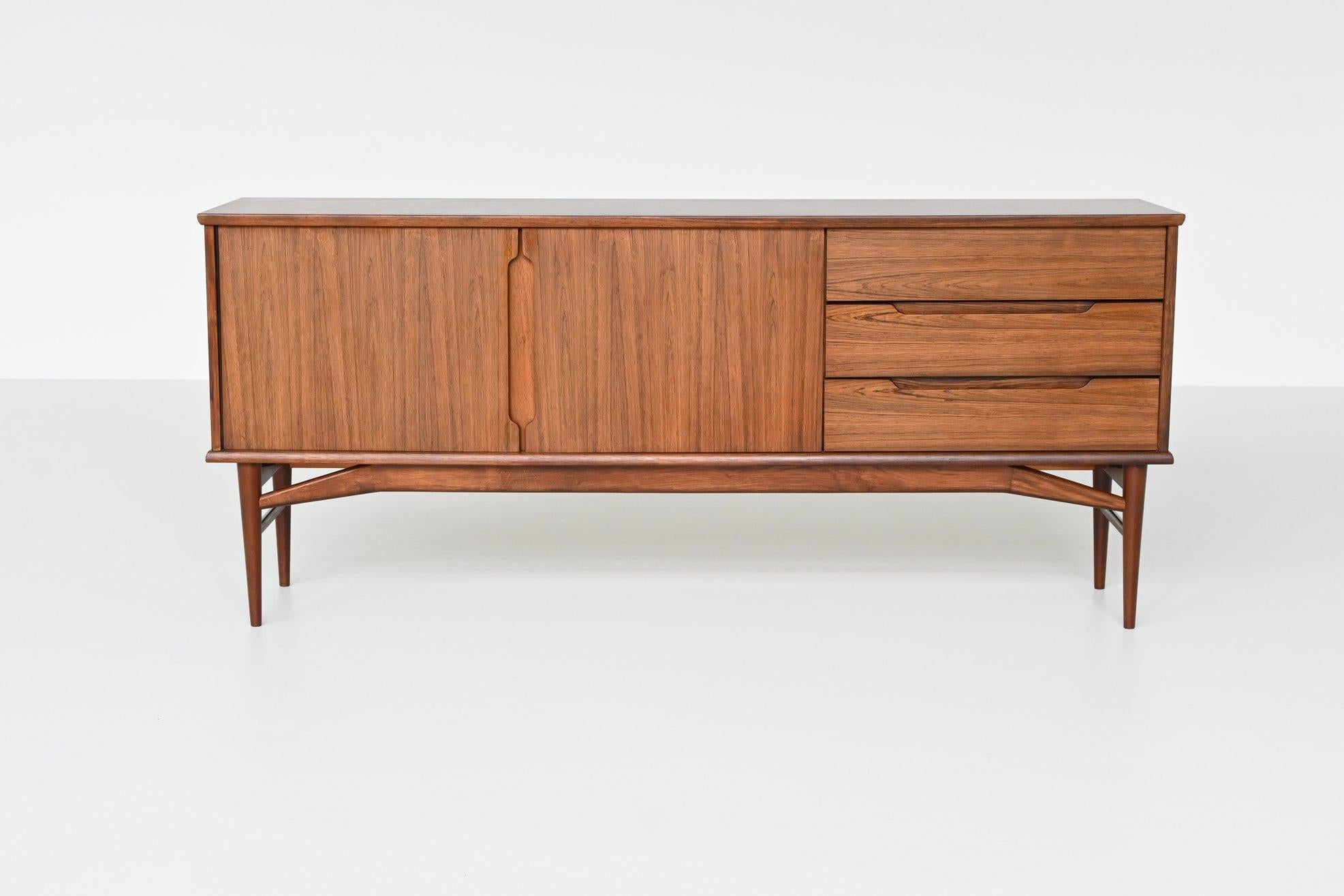 Wonderful Danish sideboard designed by Borge Mogensen and manufactured by Fredericia Stolefabrik, Denmark 1960. This sideboard is made of beautiful grained veneered rosewood with solid legs. It has two doors with a shelf behind and three drawers so
