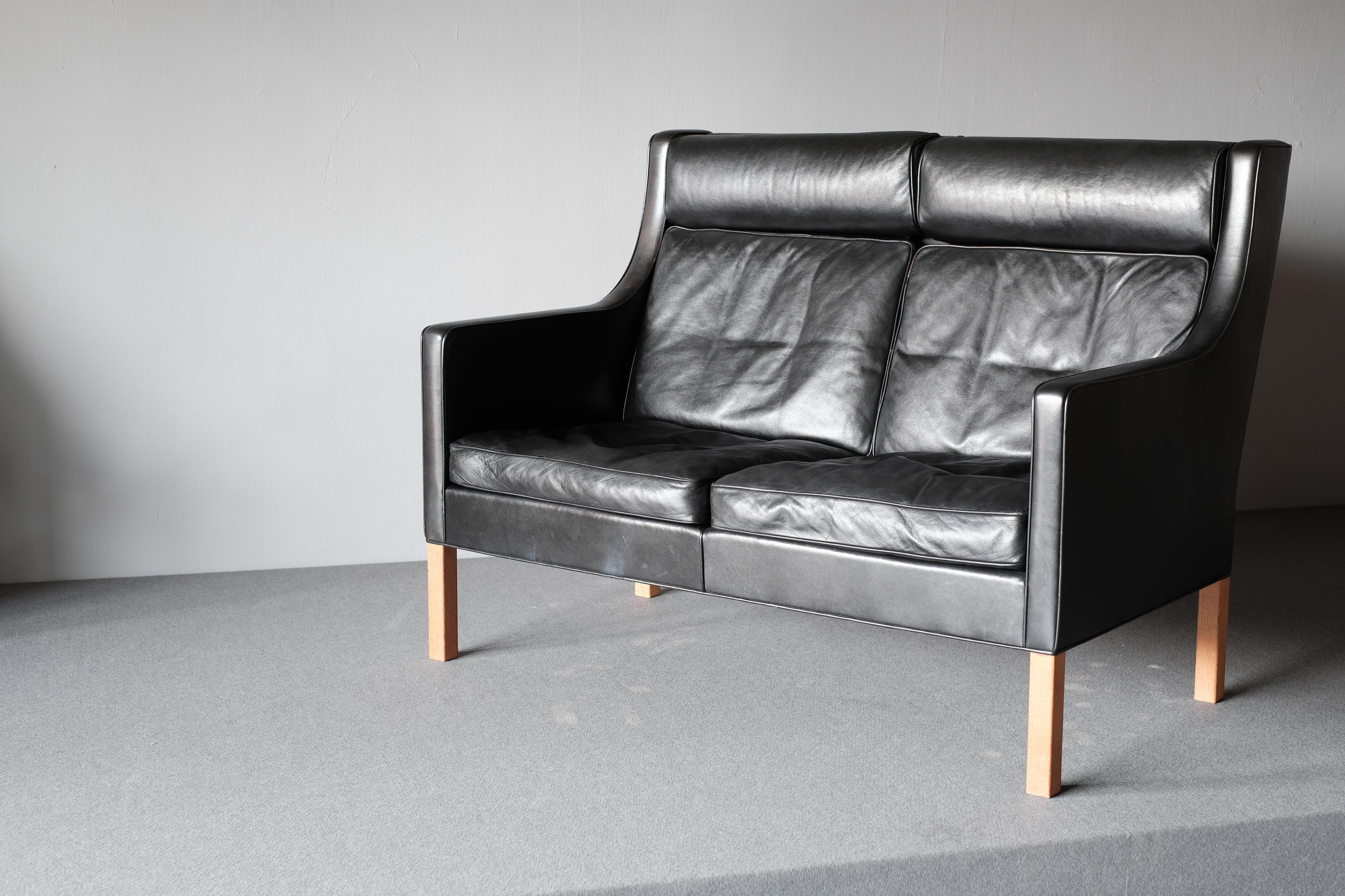 2-seat sofa by Borge Mogensen, manufactured by Fredericia. This model 2432 is upholstered in wonderfully patinated black leather and has legs in oak. 

The wonderful quality of the sofa made from solid oak, upholstered in high grade leather and