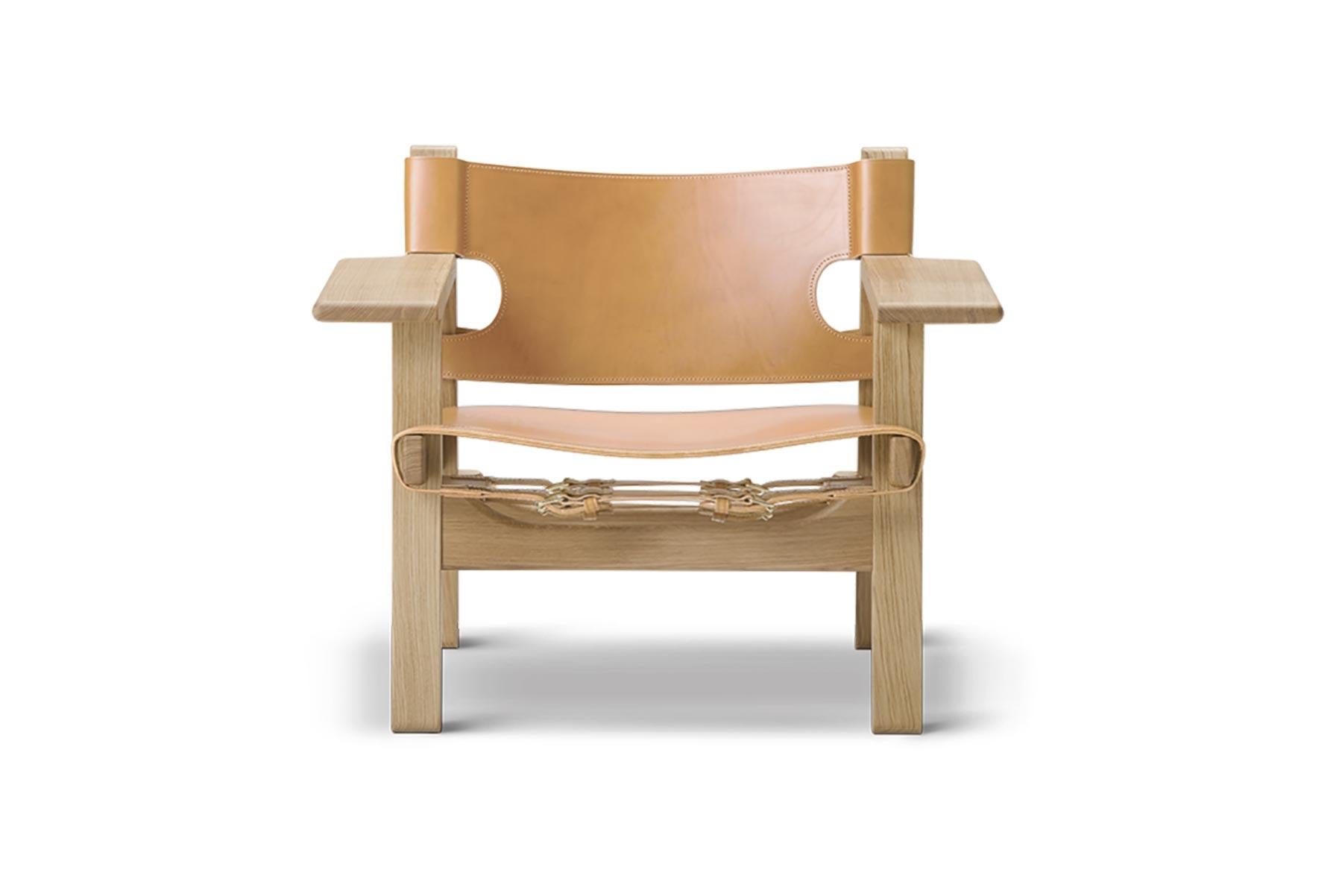 Avec la chaise espagnole, Mogensen a poursuivi son travail sur le chêne massif et le cuir de selle. La chaise a été lancée en 1958 dans le cadre d'une exposition innovante sur l'espace de vie, dans laquelle toutes les tables étaient retirées du sol