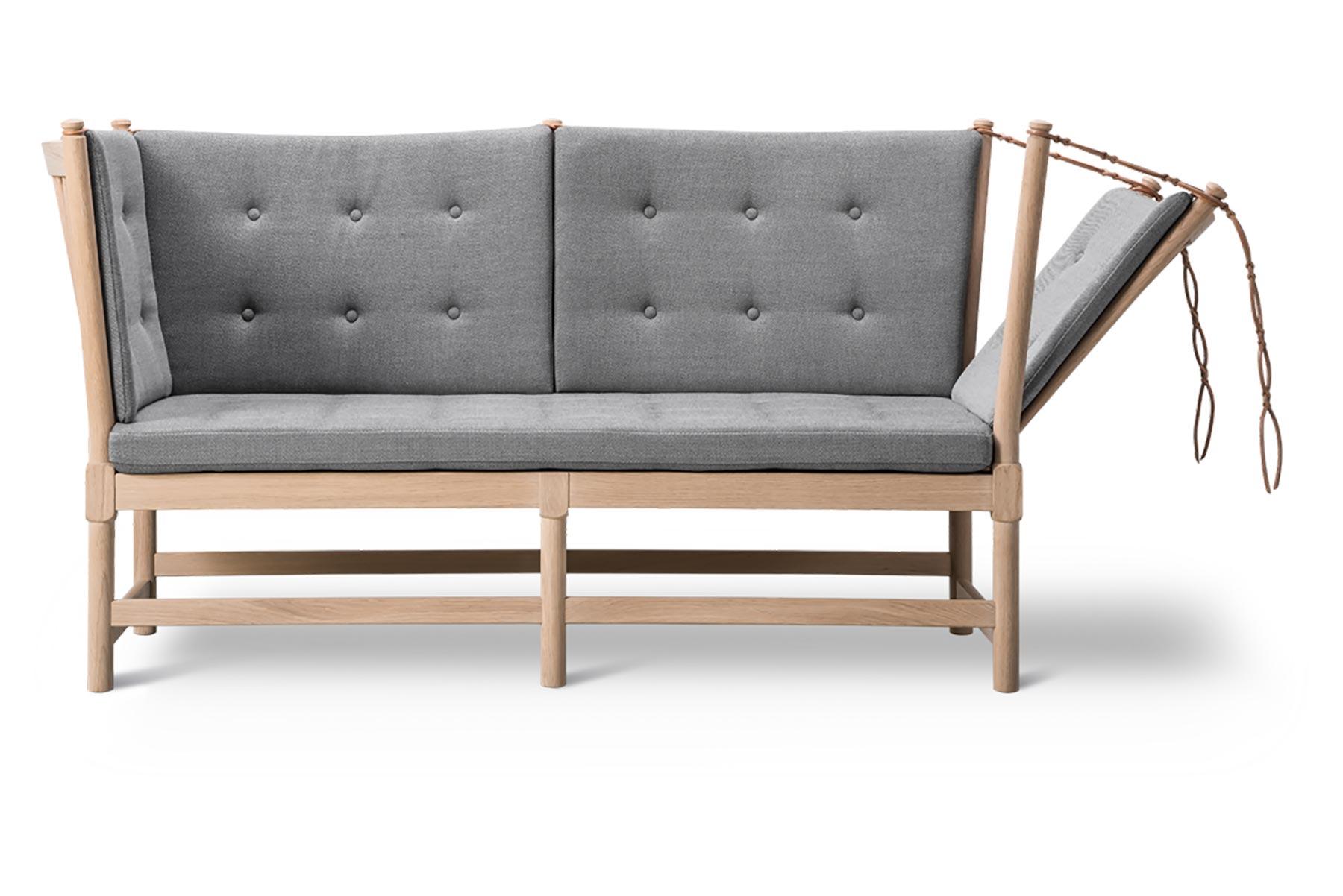Mogensen a conçu le canapé à dossier en 1945 comme un hybride de lit de jour et de chaise longue, avec un côté articulé. La construction apparente était trop sophistiquée pour la culture modeste de l'après-guerre et le canapé n'est entré en
