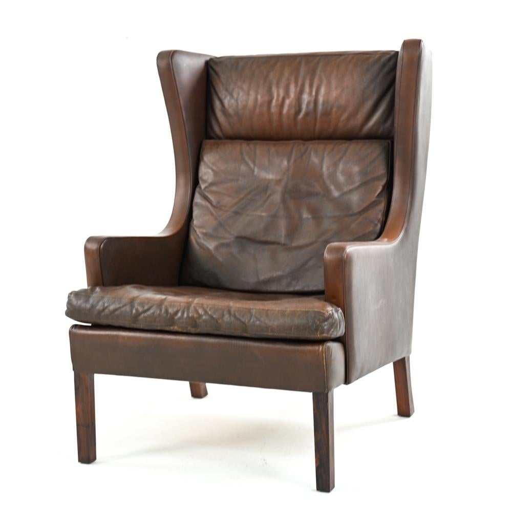 Danish mid-century wingback lounge chair in brown leather in the style of Borge Mogensen.