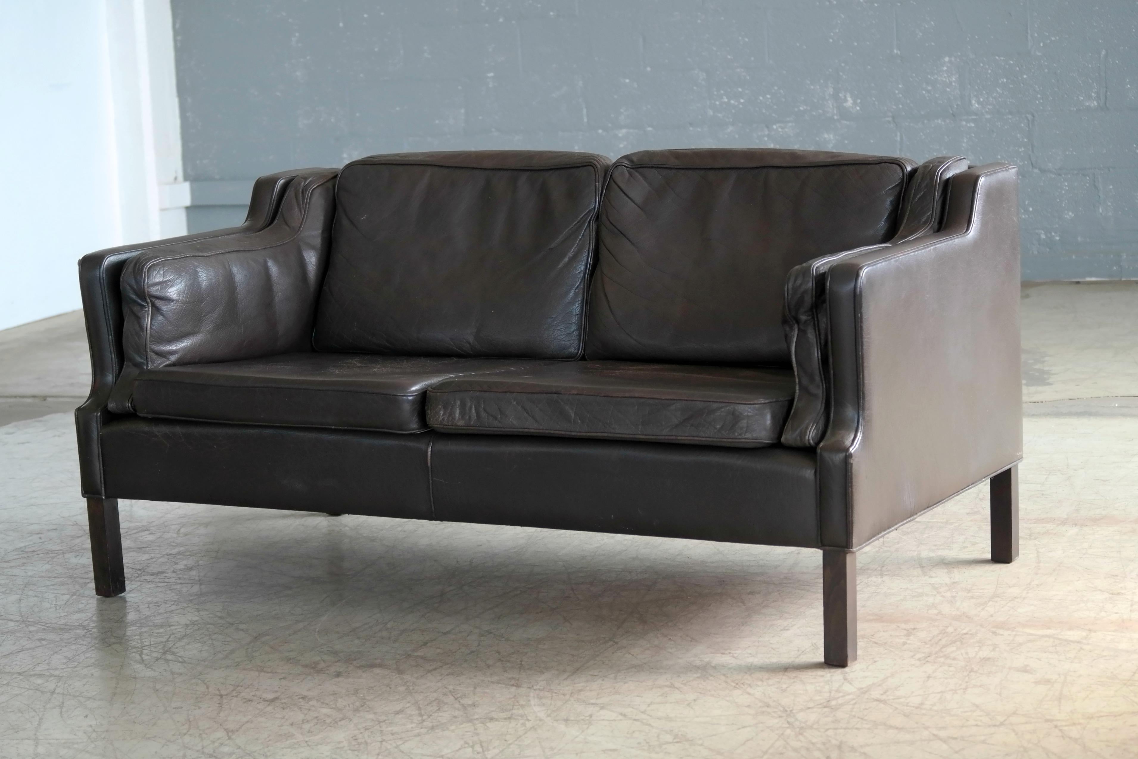 Classic Børge Mogensen style loveseat in dark brown colored buffalo leather designed by Georg Thams for Vejen Polster Møbelfabrik, Denmark. Very nice quality leather with great patina and normal age wear. Seat cushions are foam filled and back