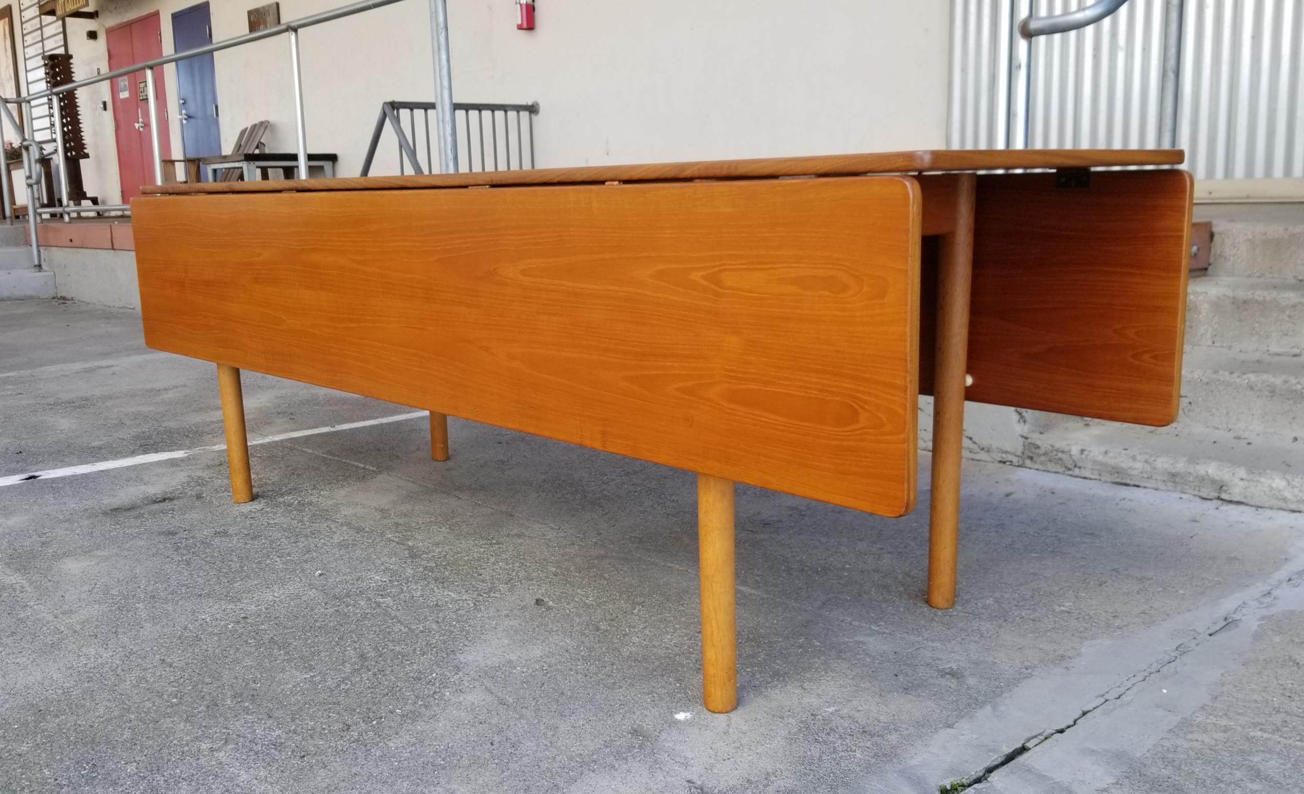 A scarce oversized example of the Børge Mogensen Danish Modern model 840 teak and oak drop leaf dining table measuring a massive 83.88 inches in length. This table would function very well as a console or sofa table. Fully extended measures 83.88